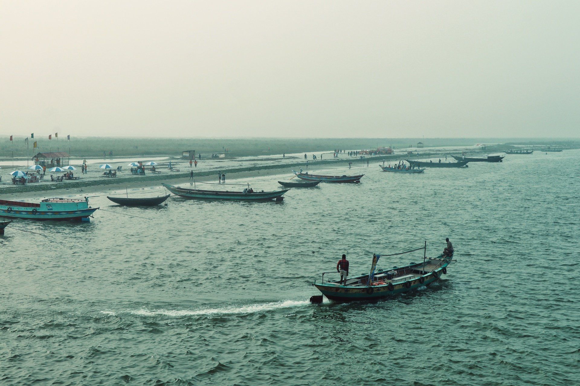 A group of boats are floating on top of a large body of water.