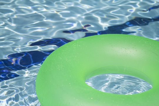 a green float is floating in a swimming pool in suffolk county