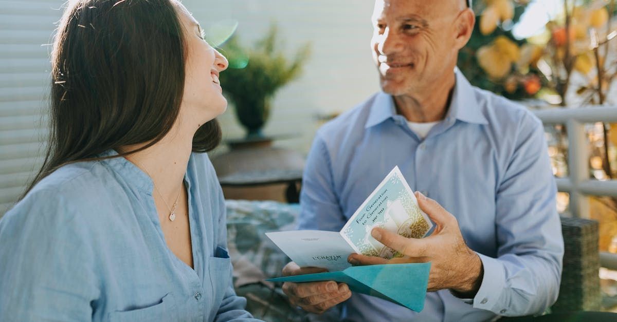 A man is giving a woman a check in an envelope.