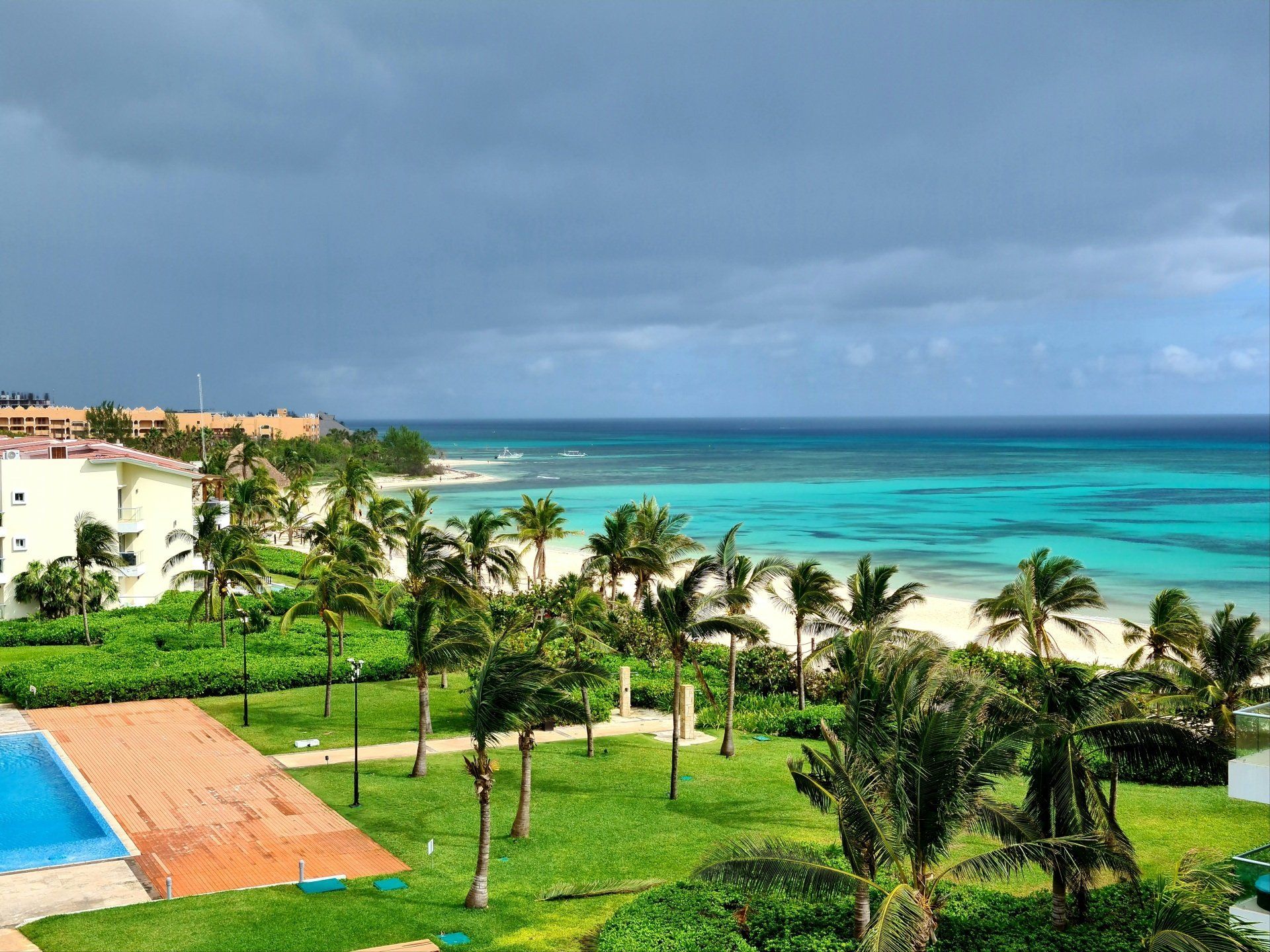 An aerial view of a tropical resort with a swimming pool and palm trees.