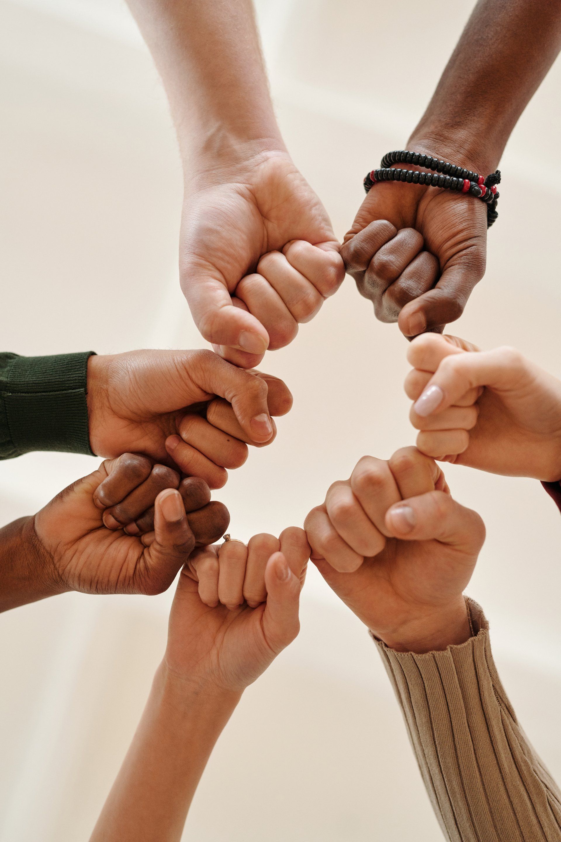 A group of people are putting their fists together in a circle.