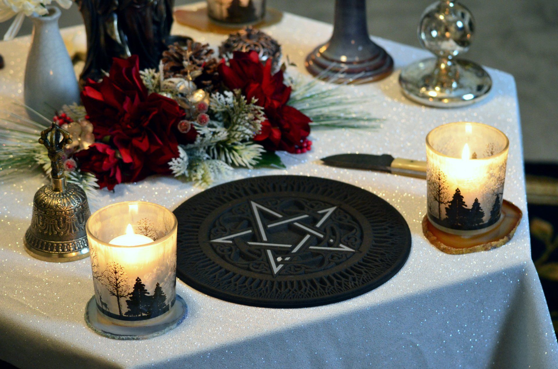 a Wiccan altar with candles, pentagram and flowers on it.