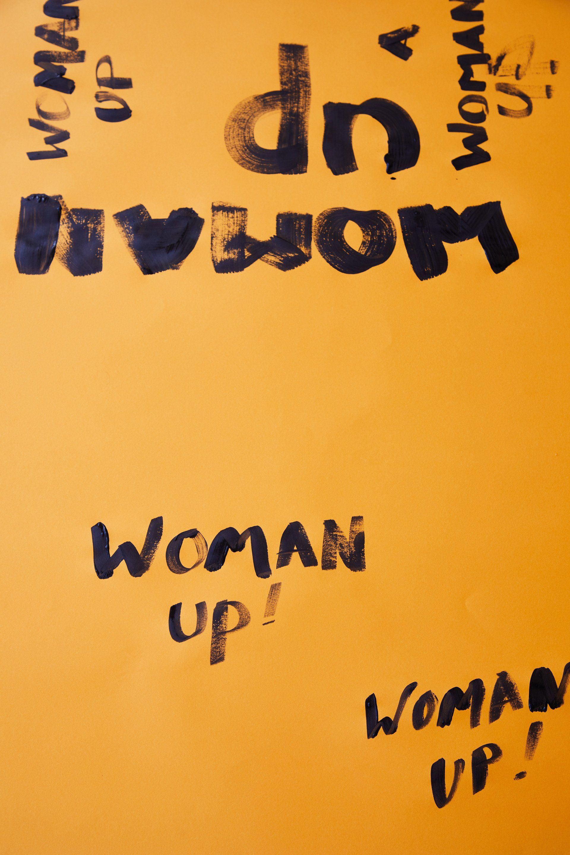 Uma placa amarela que diz mulher em cima dela