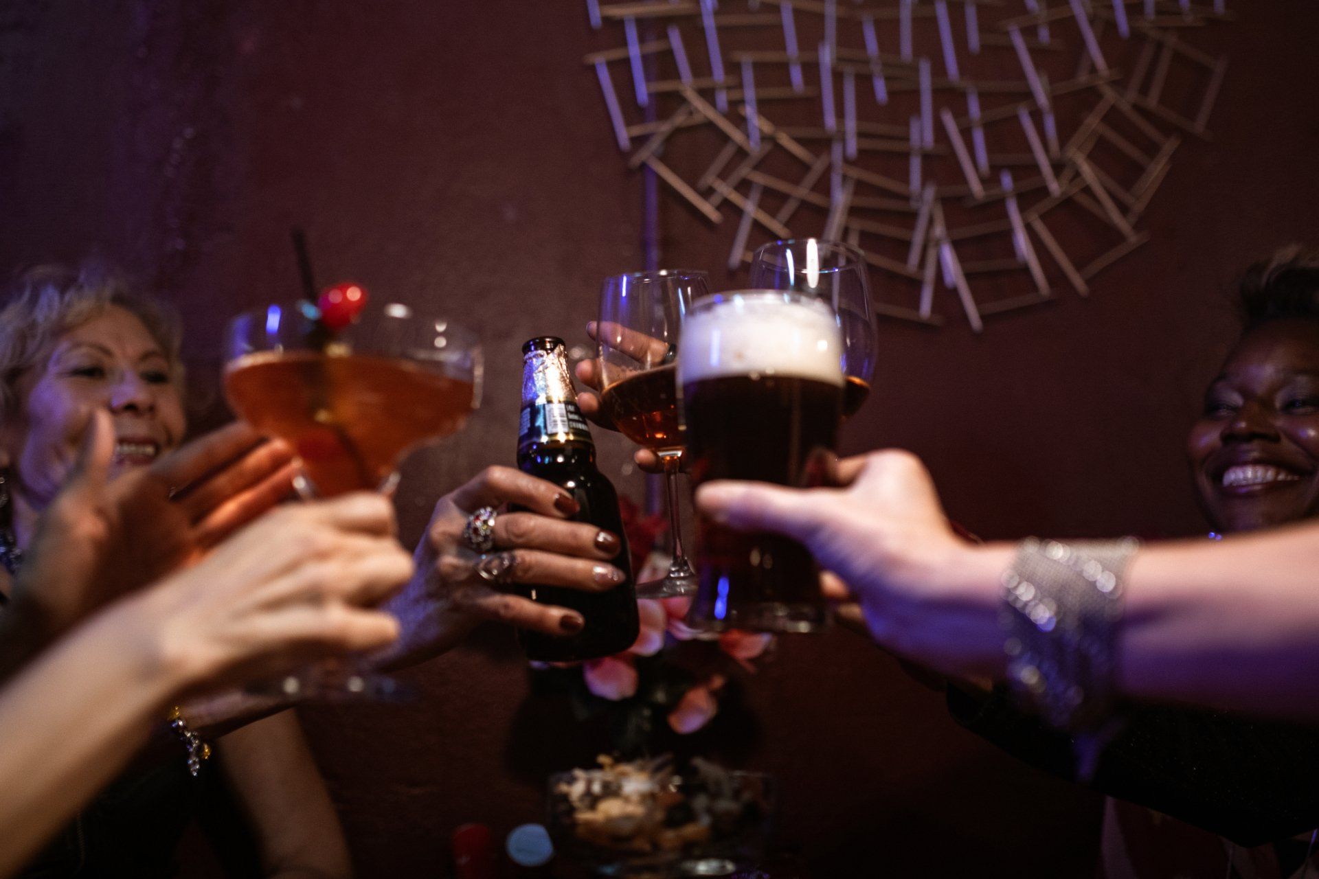a group of people are toasting with drinks 
