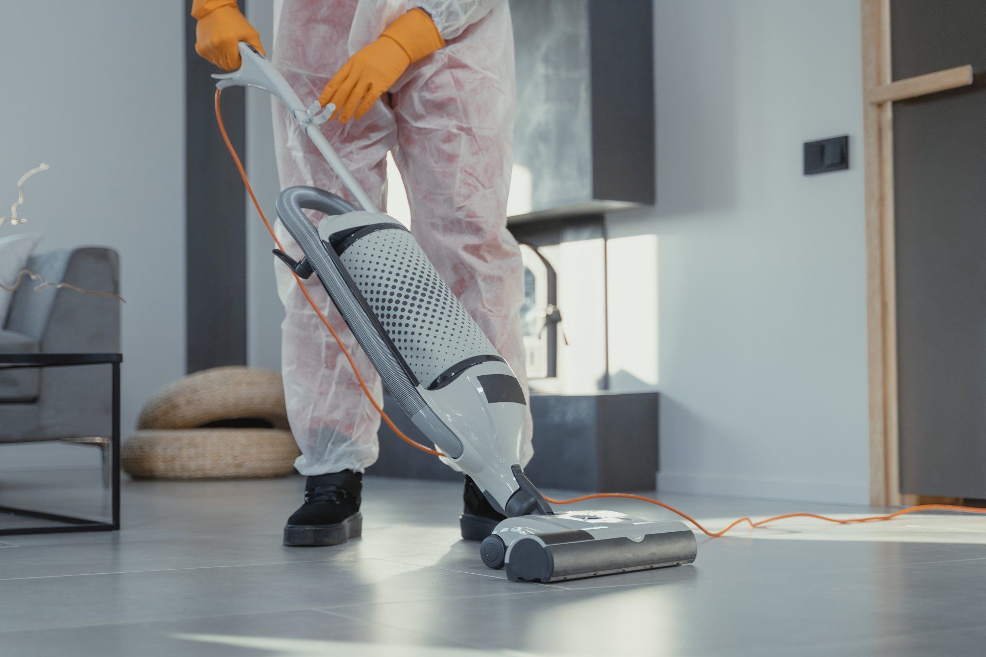 Person spraying a window with cleaning solution while wiping it with a clean fabric to remove dirt and achieve a clear, sparkling surface.