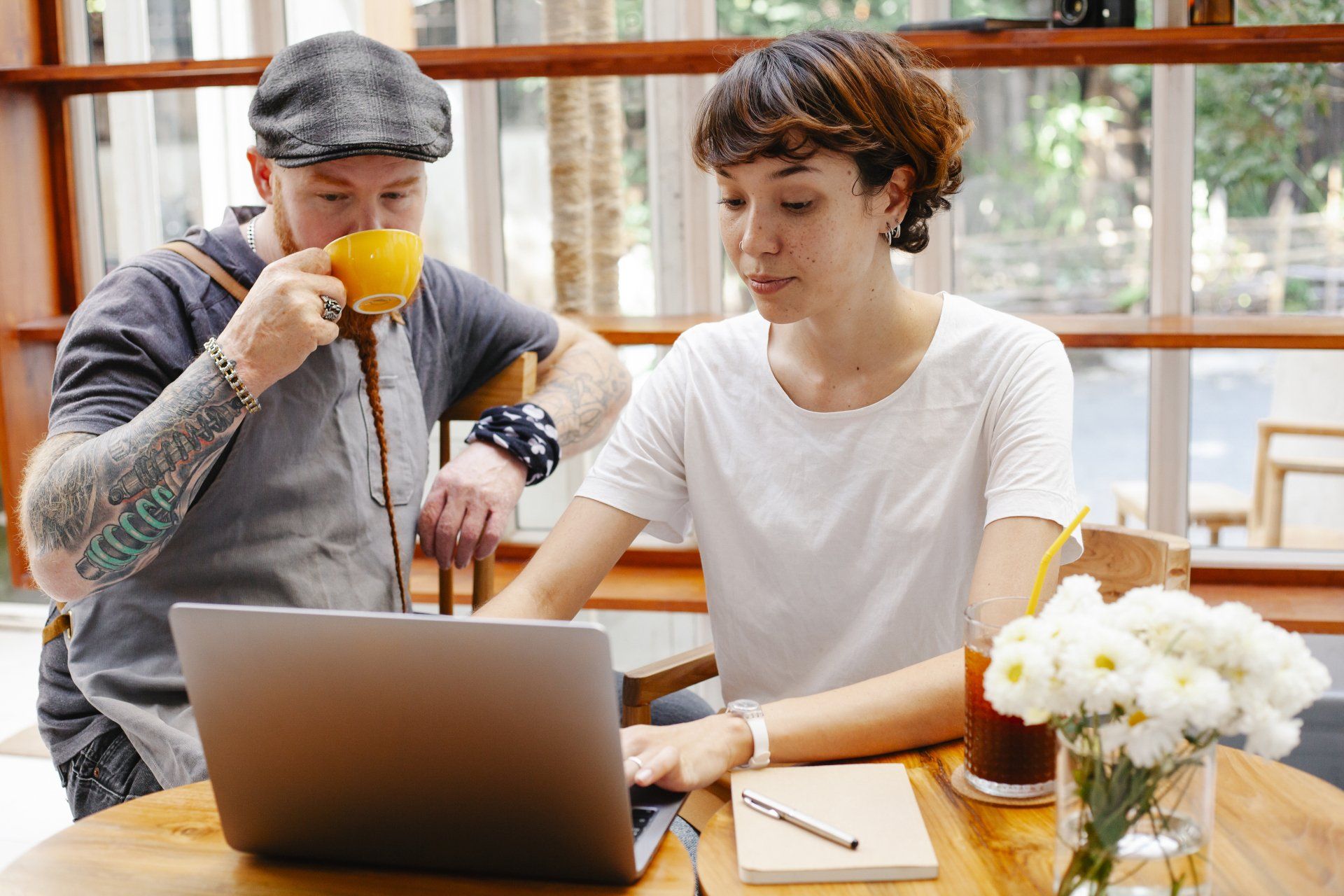 man with a coffee and a woman with her laptop