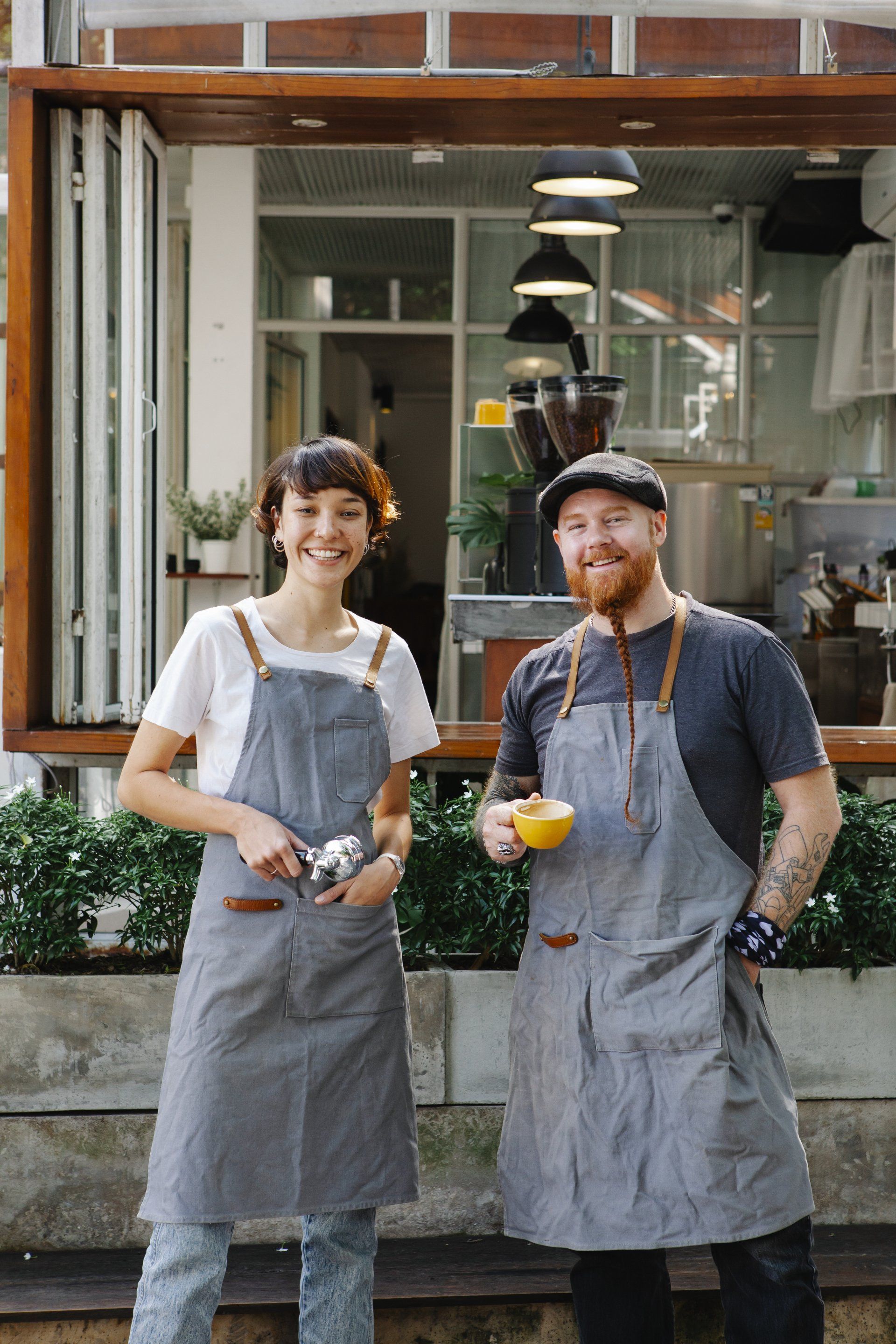 A man and a woman are standing next to each other in front of a restaurant.