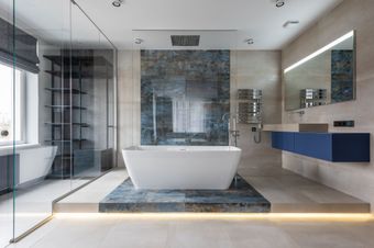 Neutral colored bathroom with a blue tile shower showcased in the center.