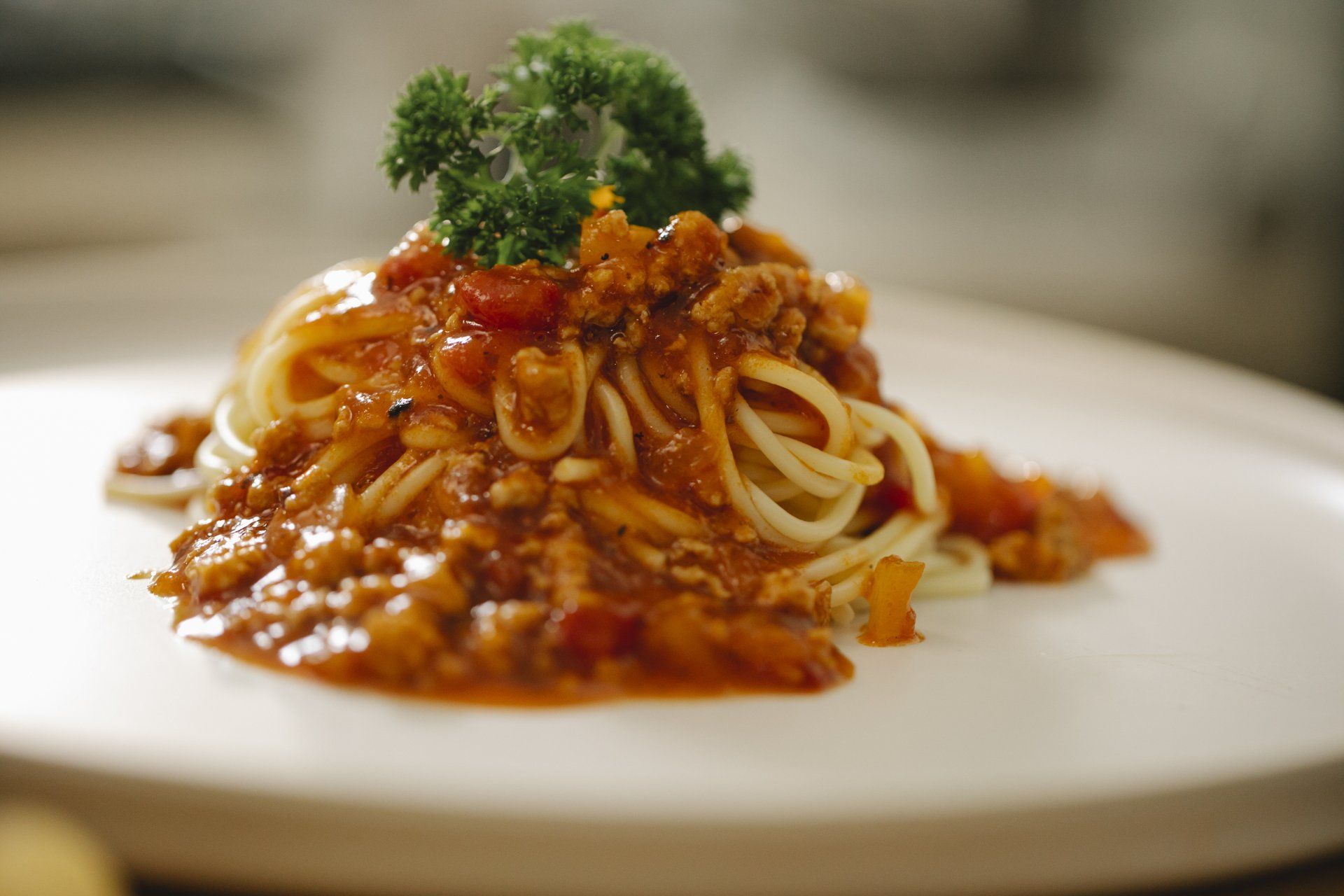A white plate topped with spaghetti and meat sauce.