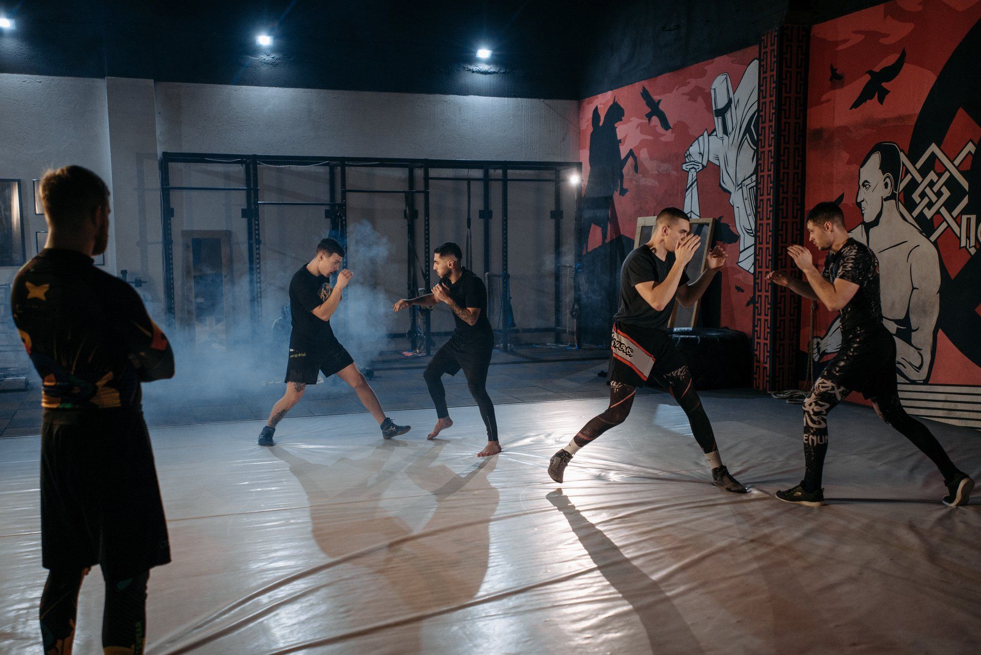 A group of men are practicing martial arts in a gym.
