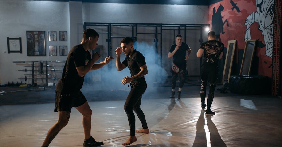 A group of men are practicing martial arts in a gym.