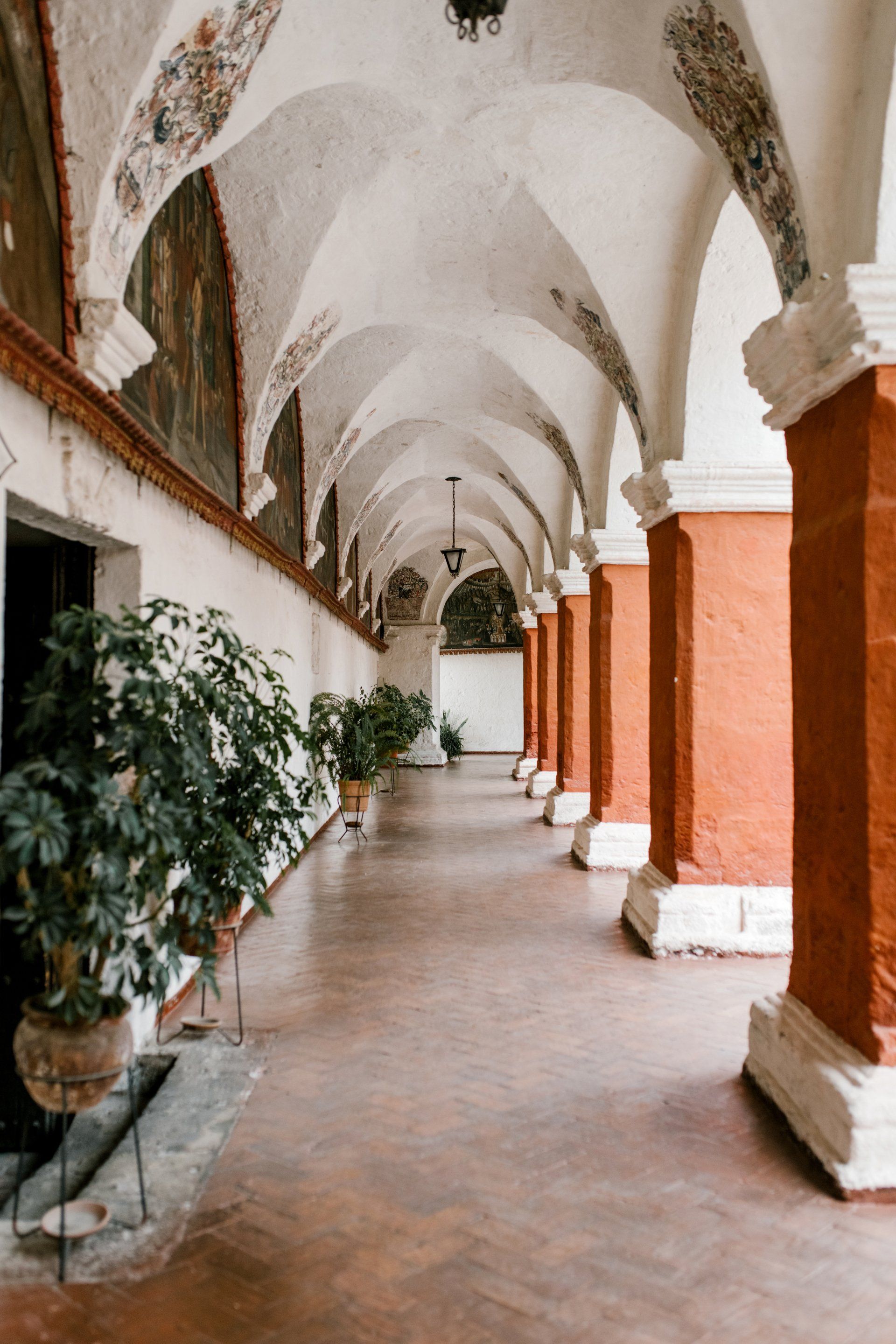 A long hallway with arches and columns in a building.