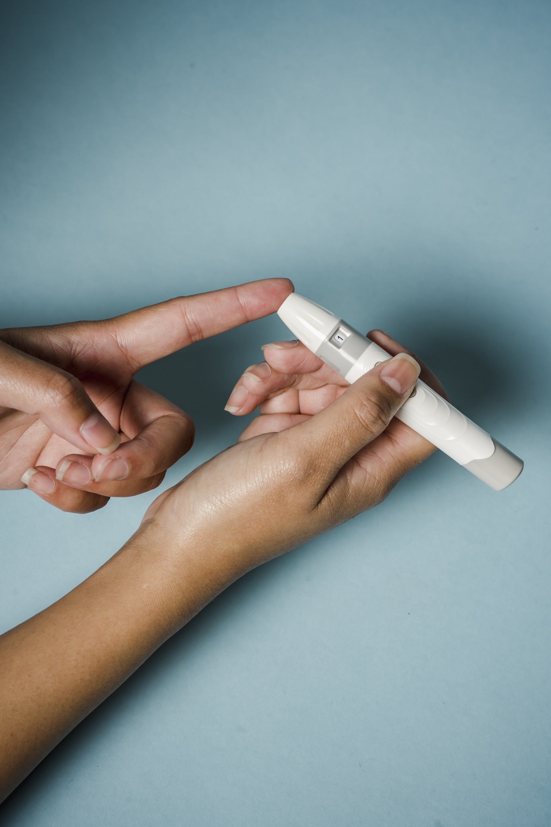 a small glucose meter being used to test the blood of a diabetic