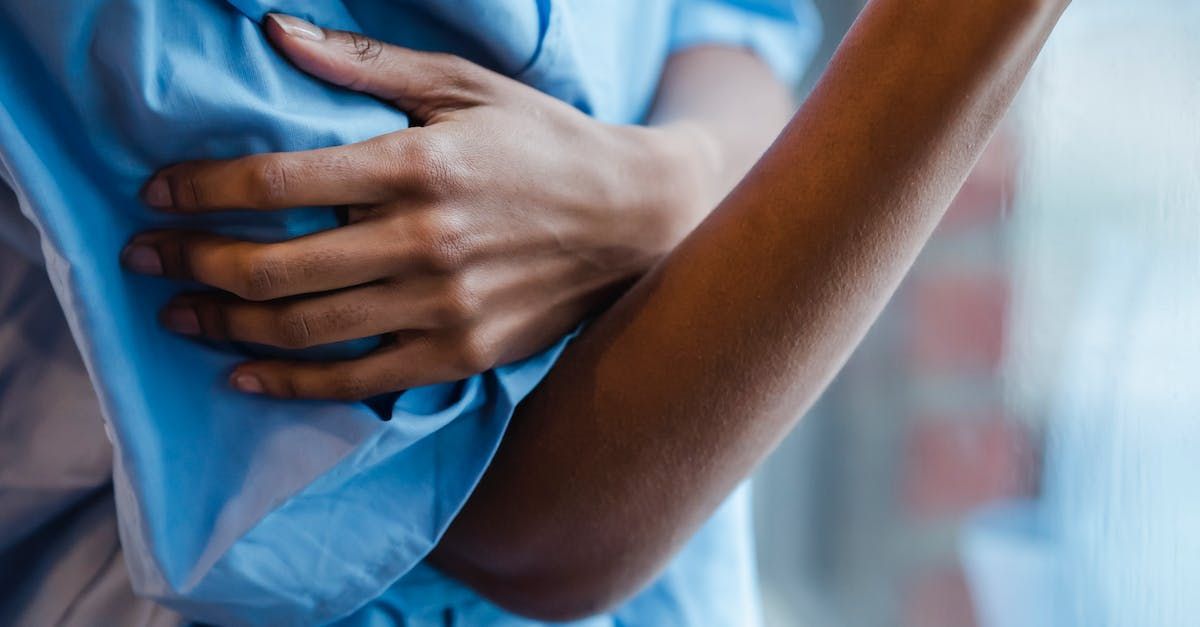 A close up of a person holding their chest in pain.