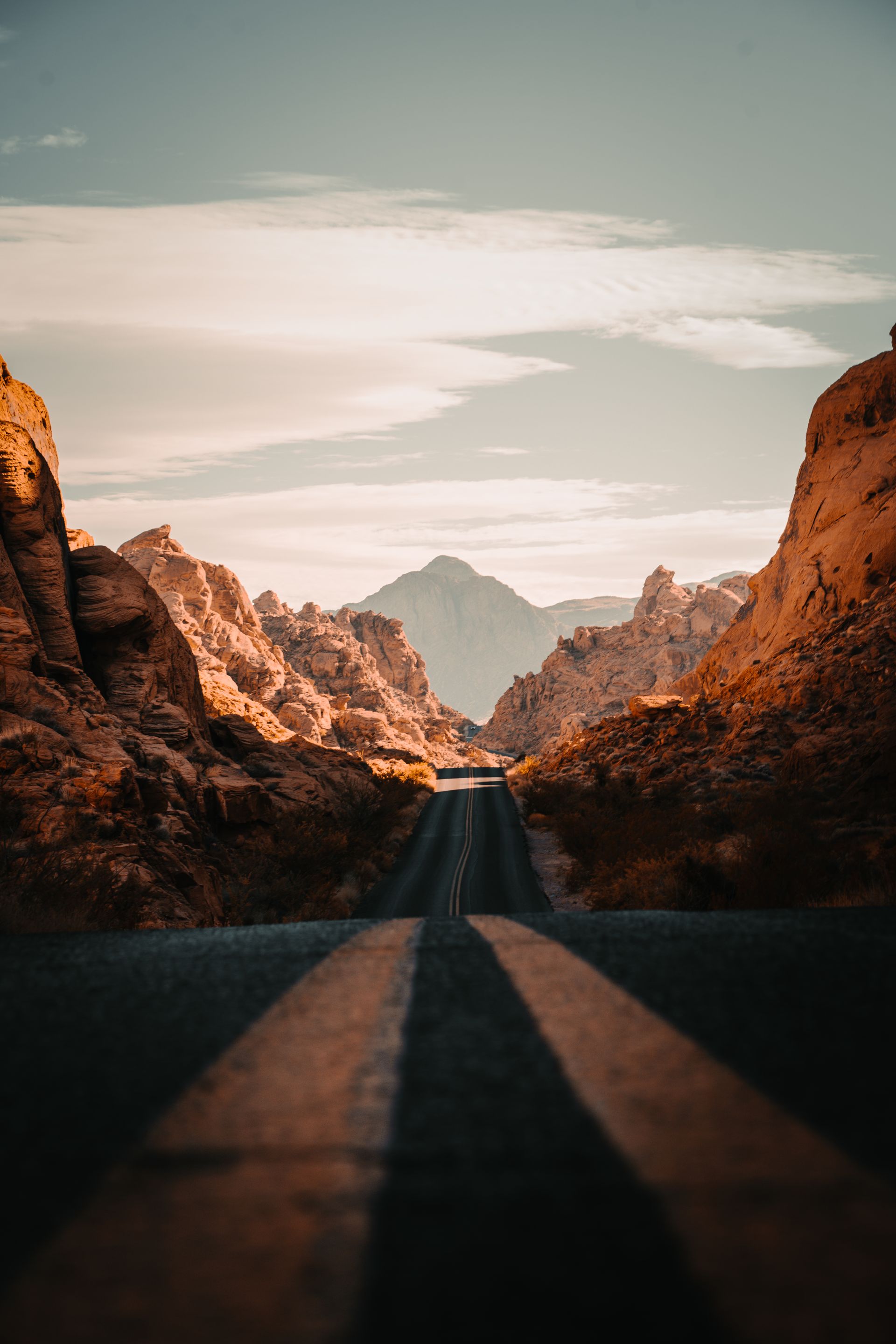 A road going through a canyon with mountains in the background.