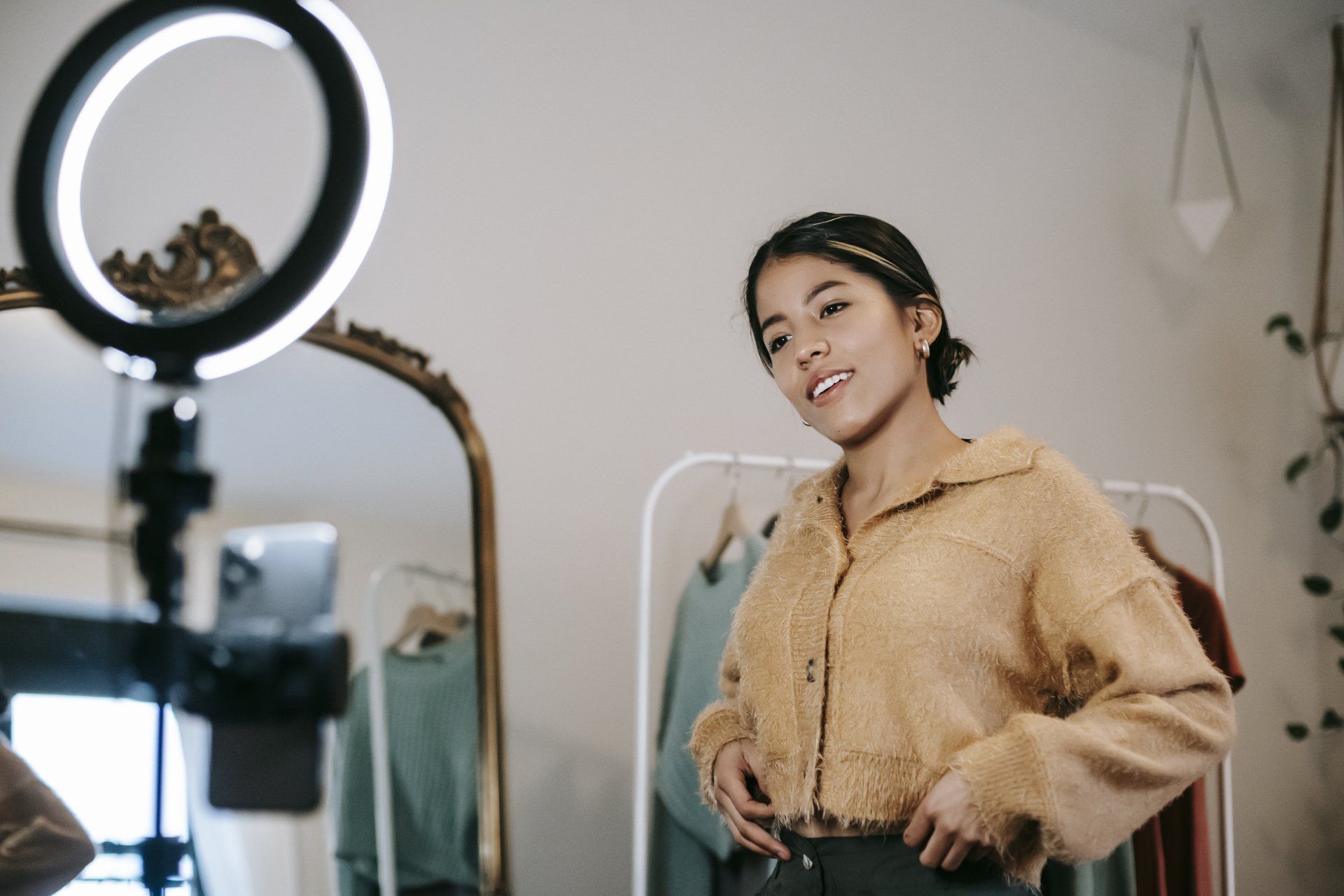 A woman is standing in front of a mirror with a ring light.