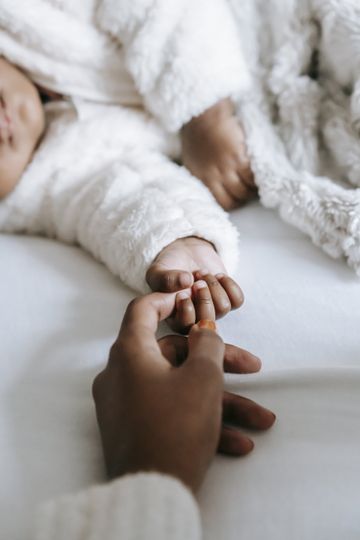 Mom's hand touching baby's hand