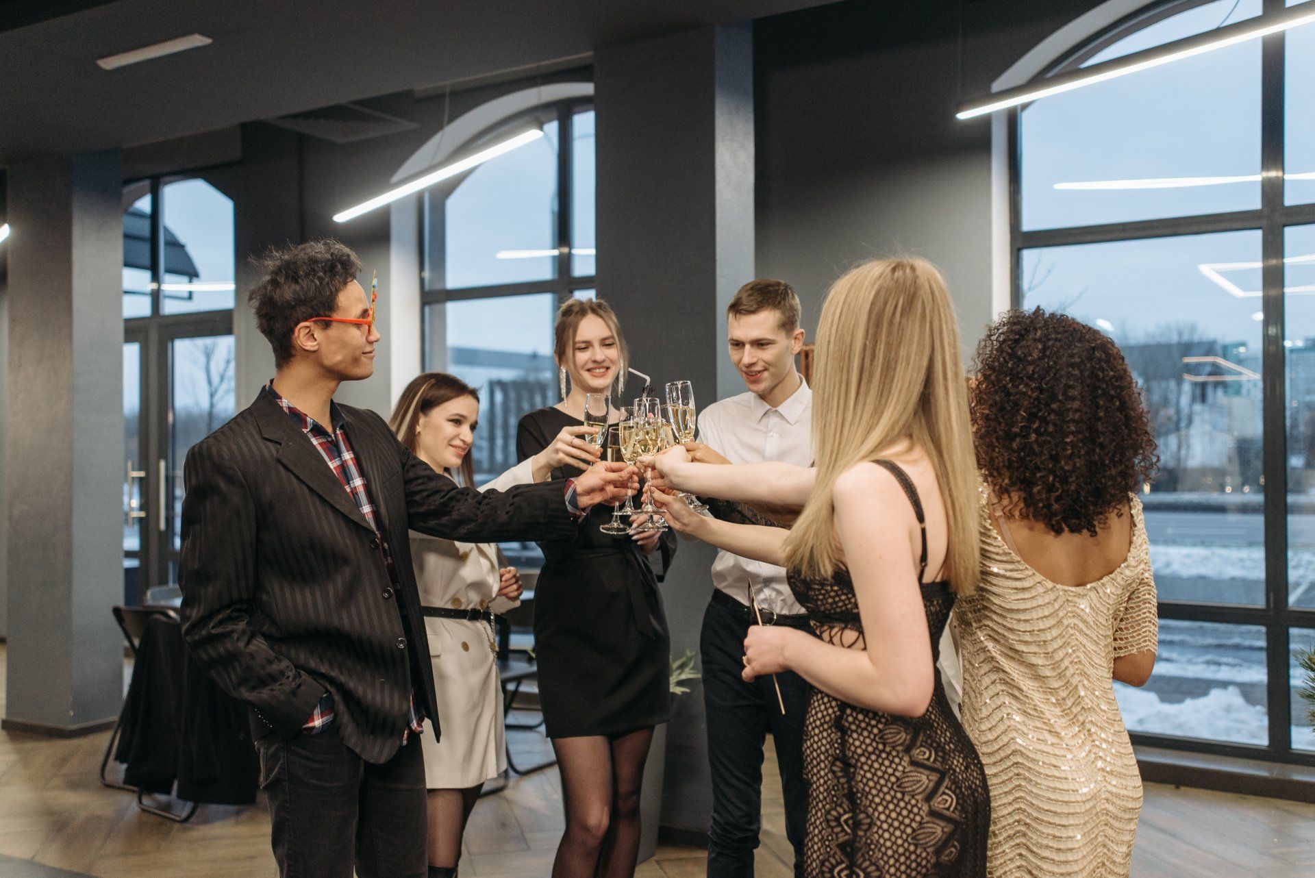 A group of people are toasting with champagne glasses at a party.