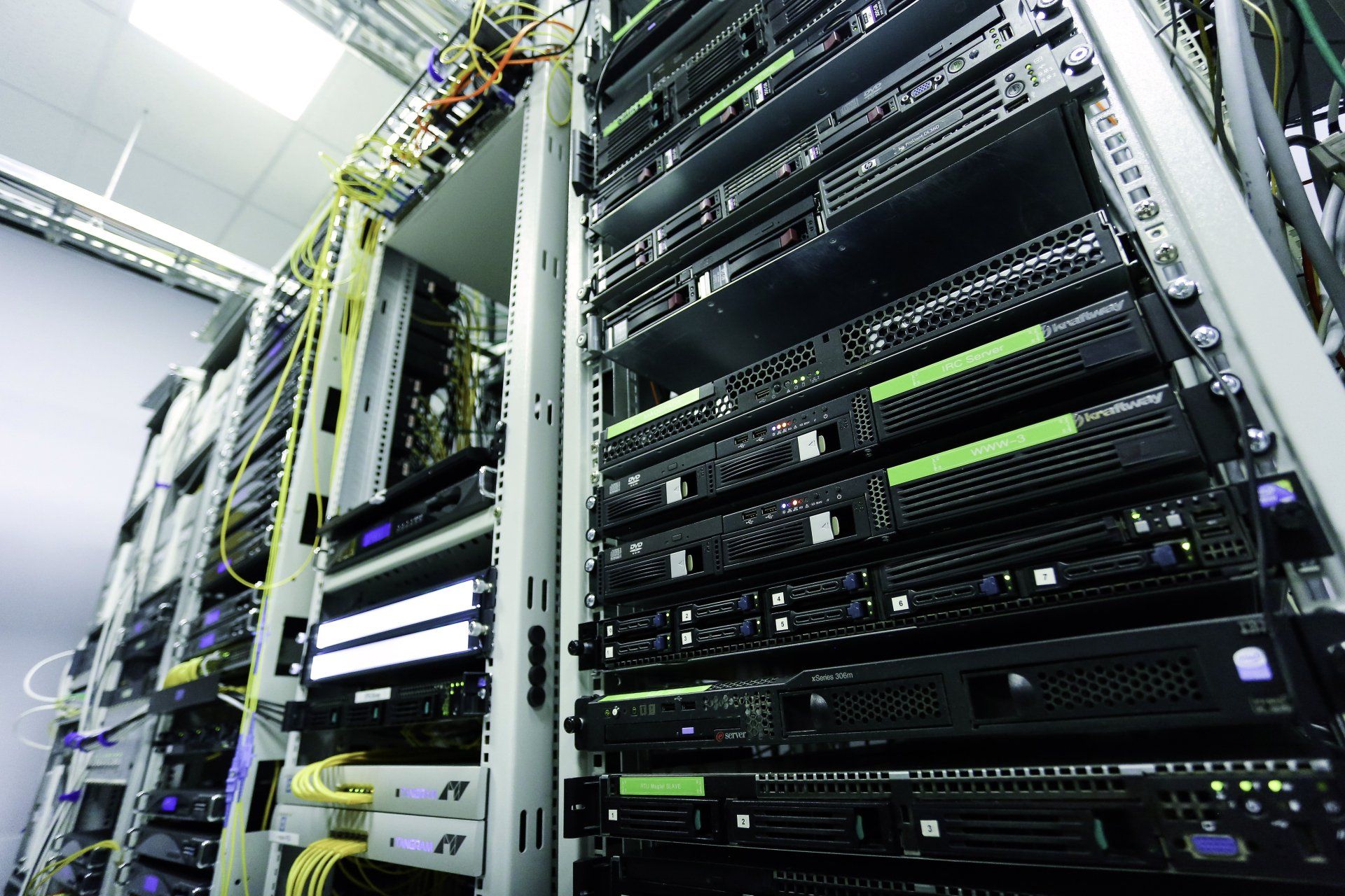 A bunch of servers are stacked on top of each other in a server room.