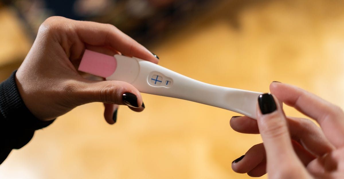 A woman is holding a pregnancy test in her hands.