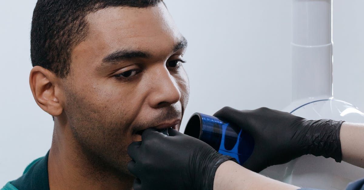 A man is getting an x-ray of his teeth by a dentist.