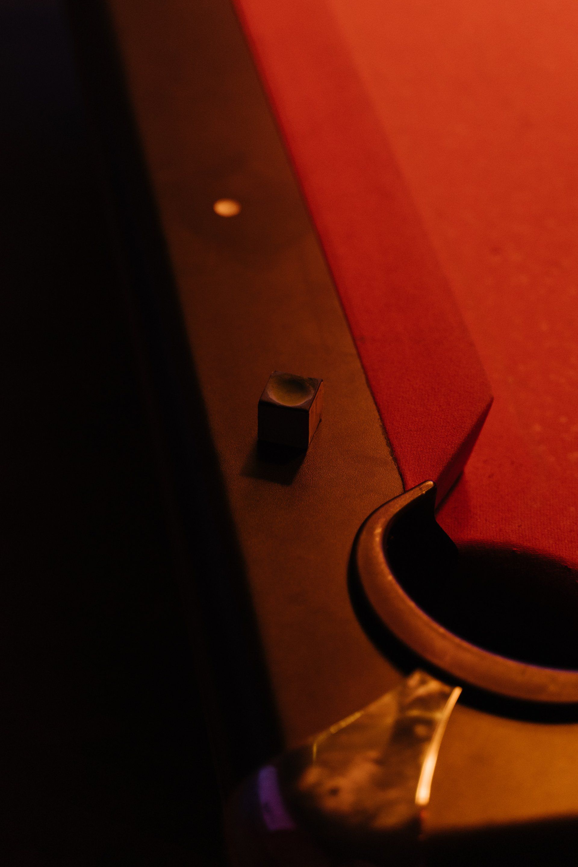 a pool table with a red cloth and a pool cue on it .