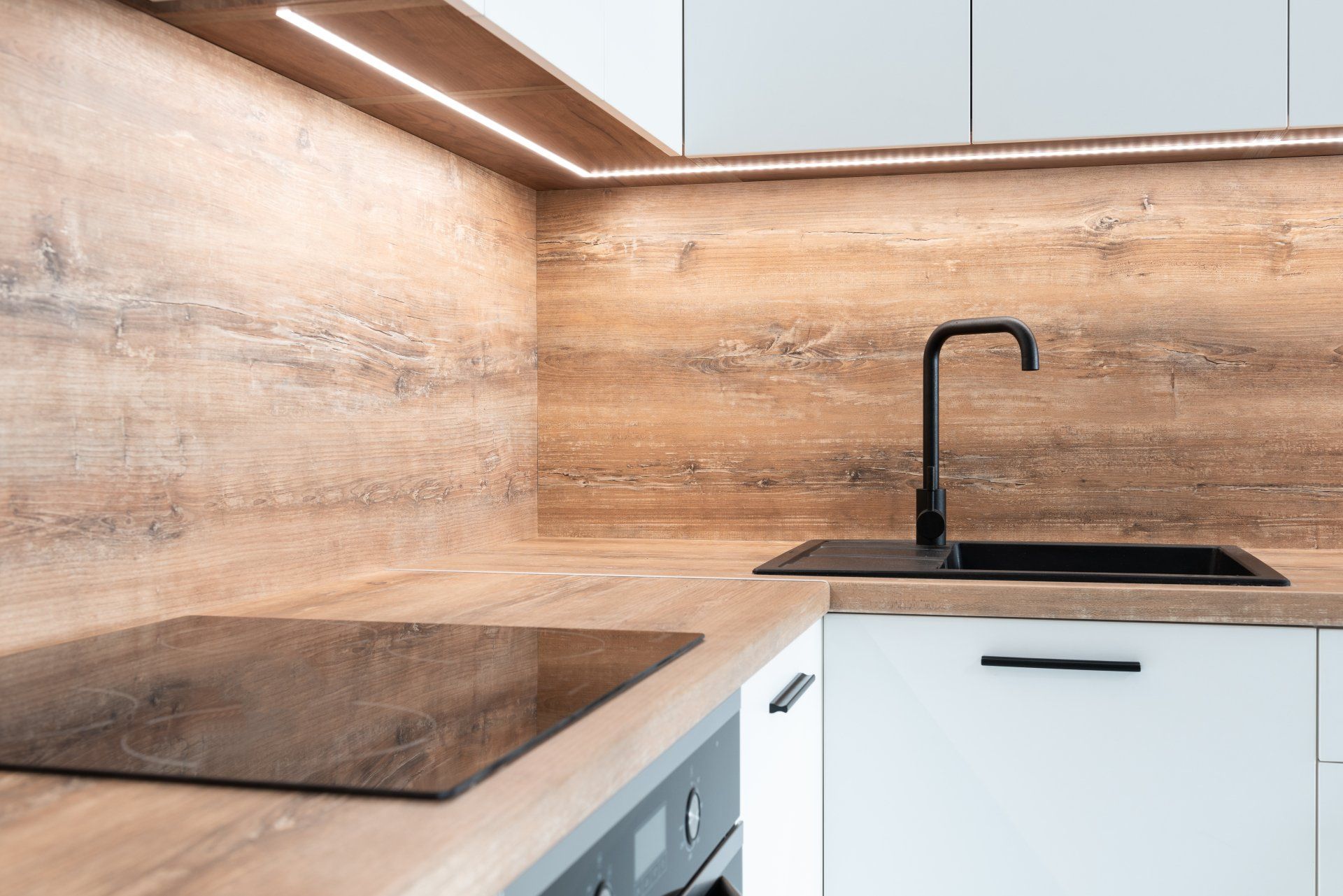a kitchen with a stove top oven , sink , and wooden wall . Transform Your Kitchen on a Budget