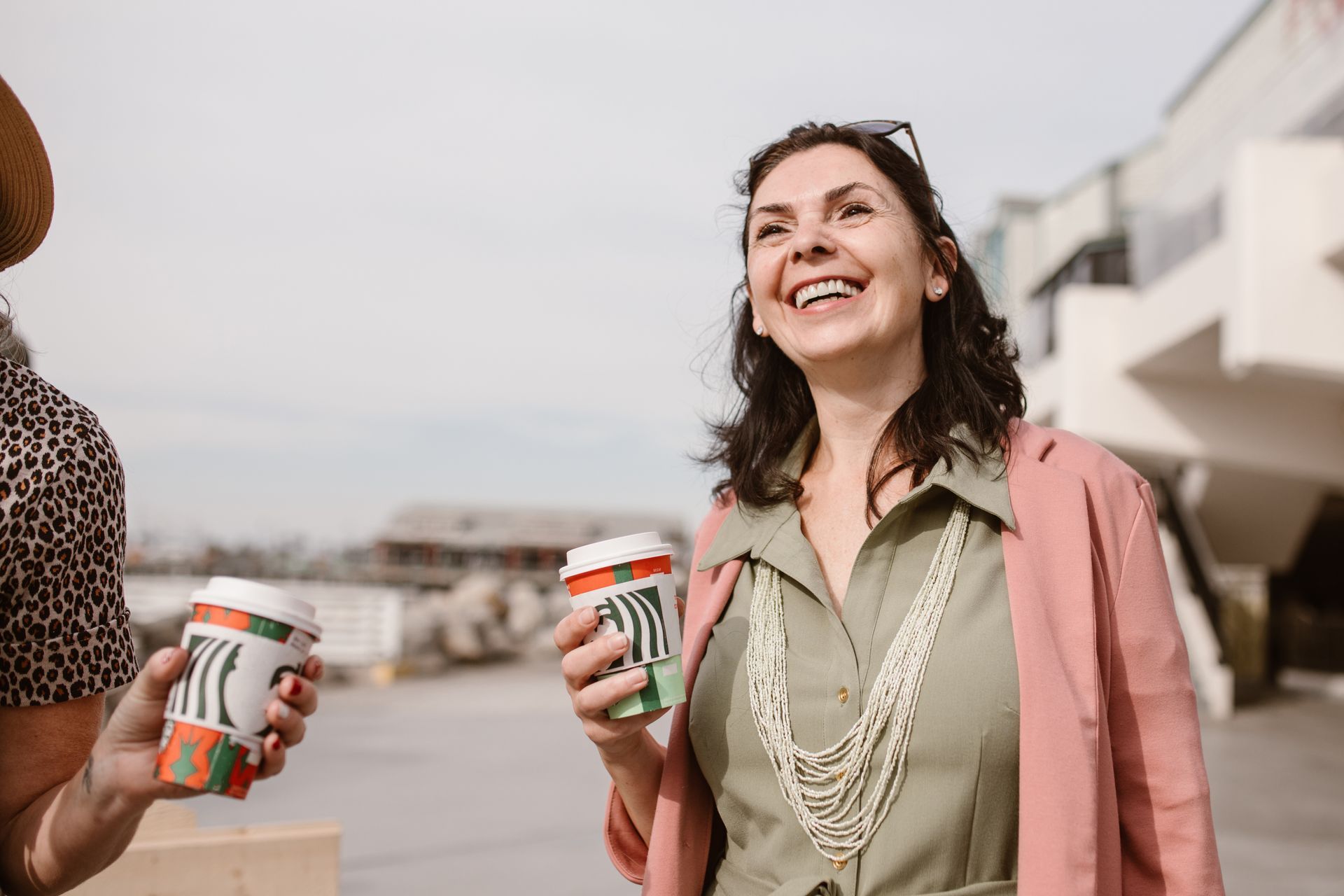 image of a woman smiling and drinking coffee