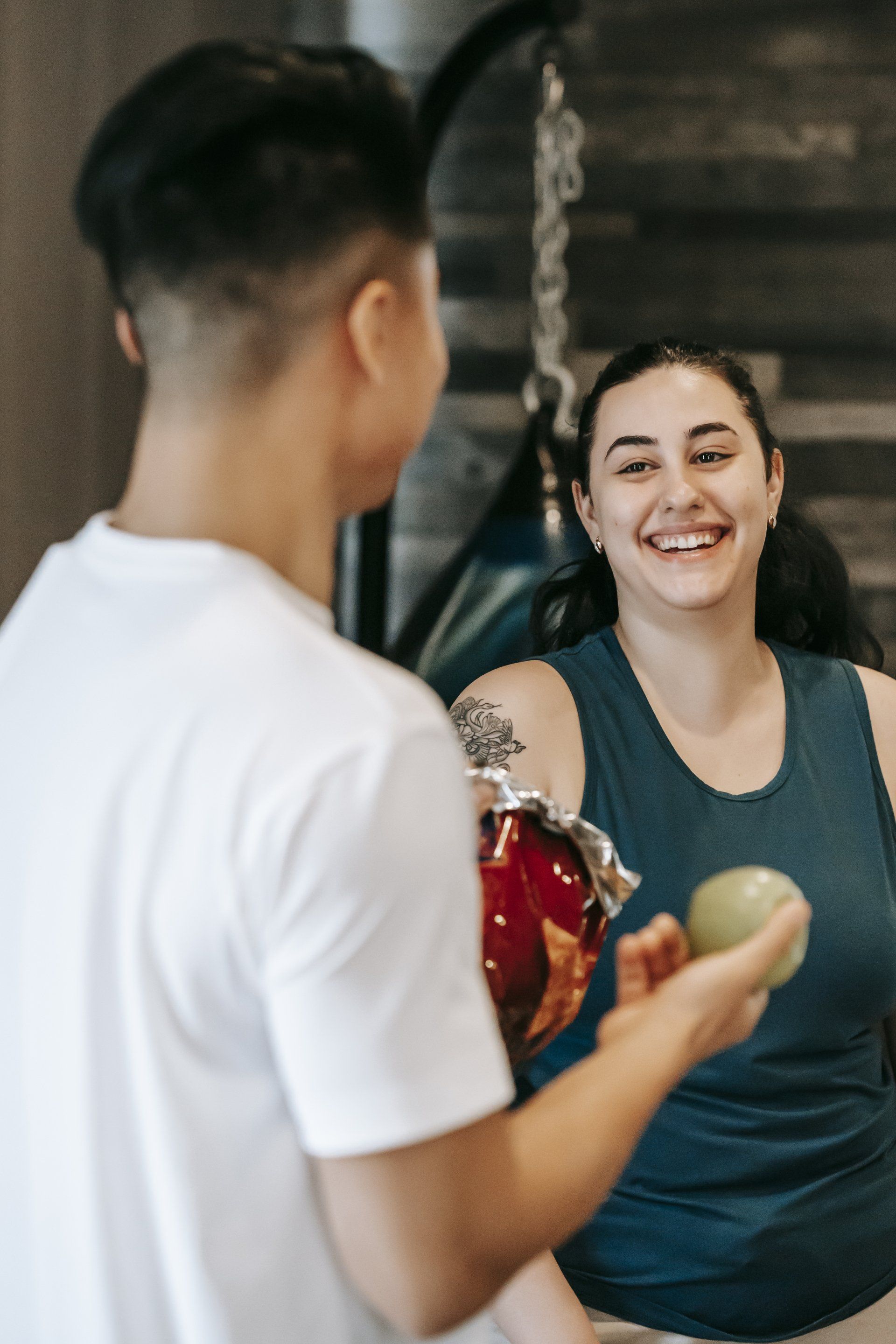 A man is giving an apple to a woman in front of a mirror.