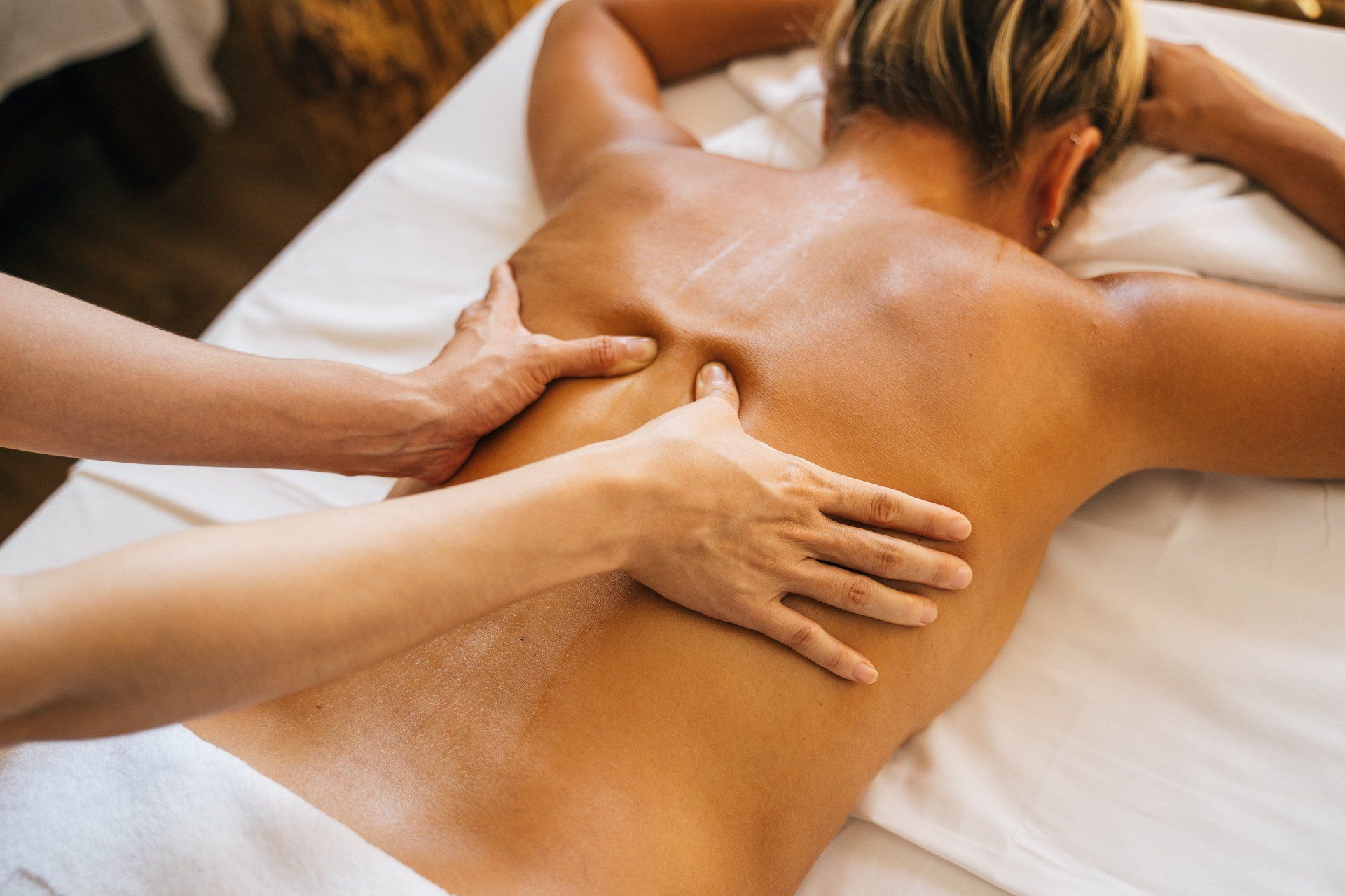 a massage therapist massaging the back of a client