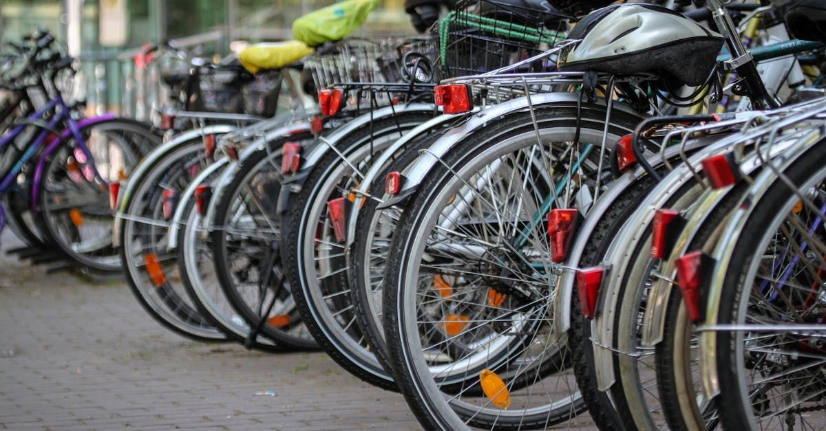 A row of bicycles are parked next to each other in a parking lot.