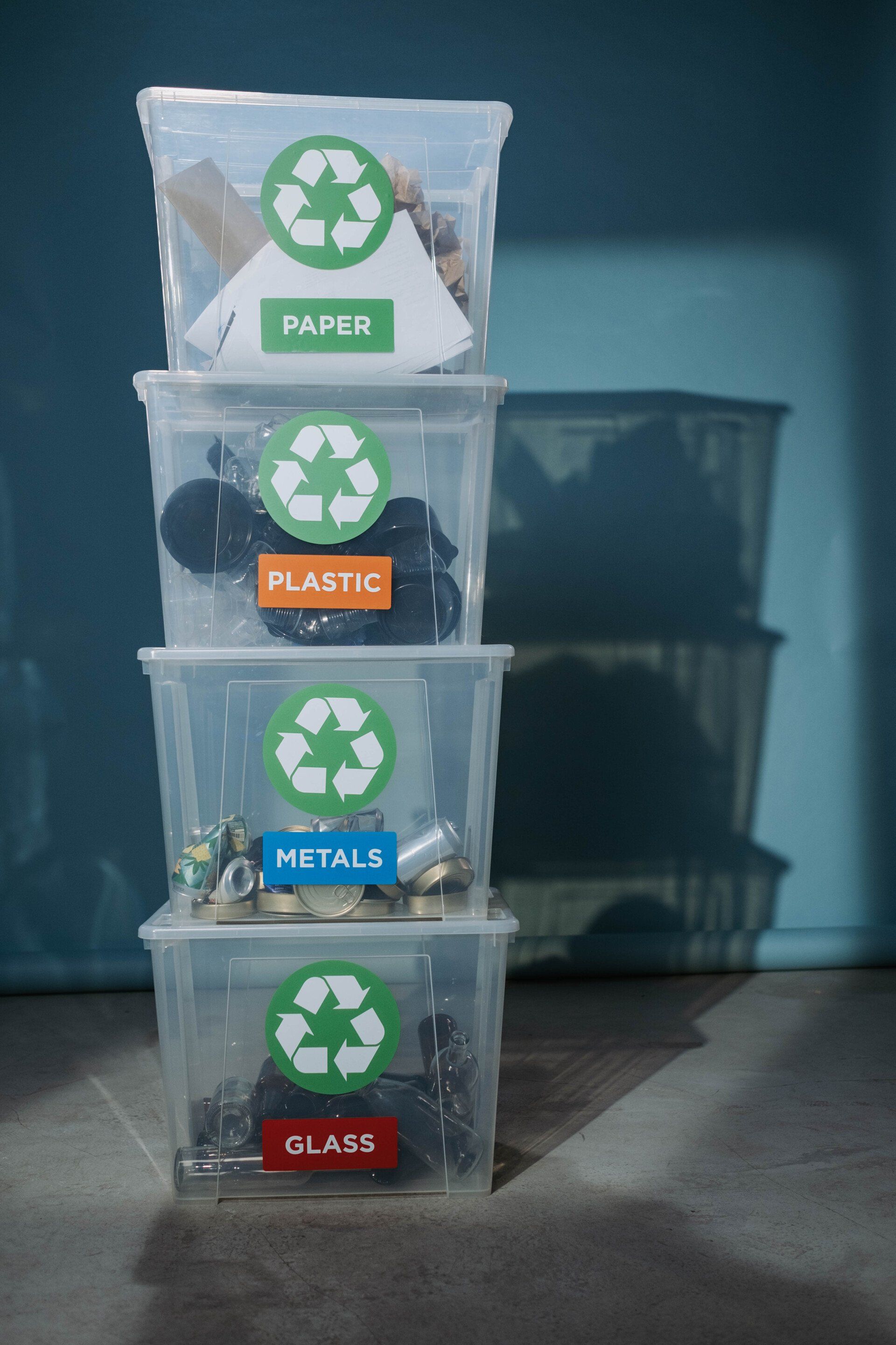 A stack of plastic bins with recycling labels on them.