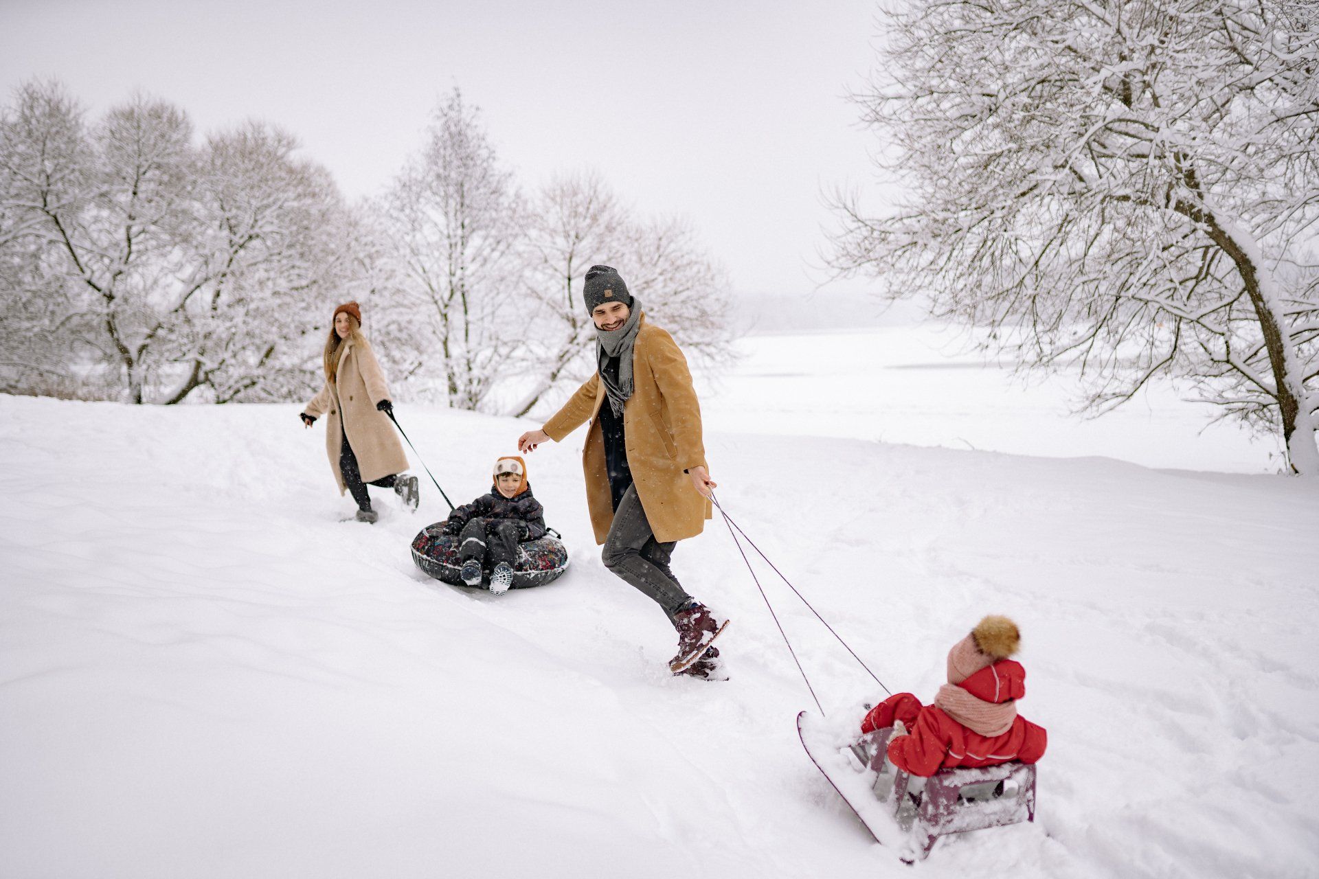 Parents pulling children on their sleds