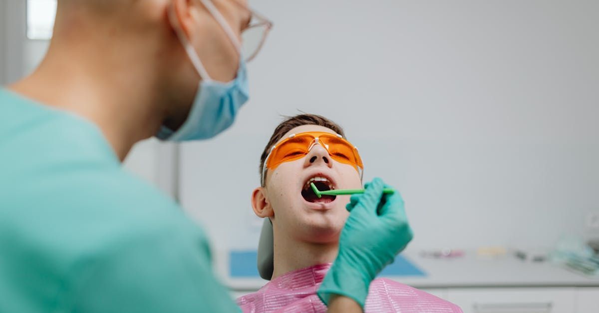 A dentist is examining a patient 's teeth in a dental office.
