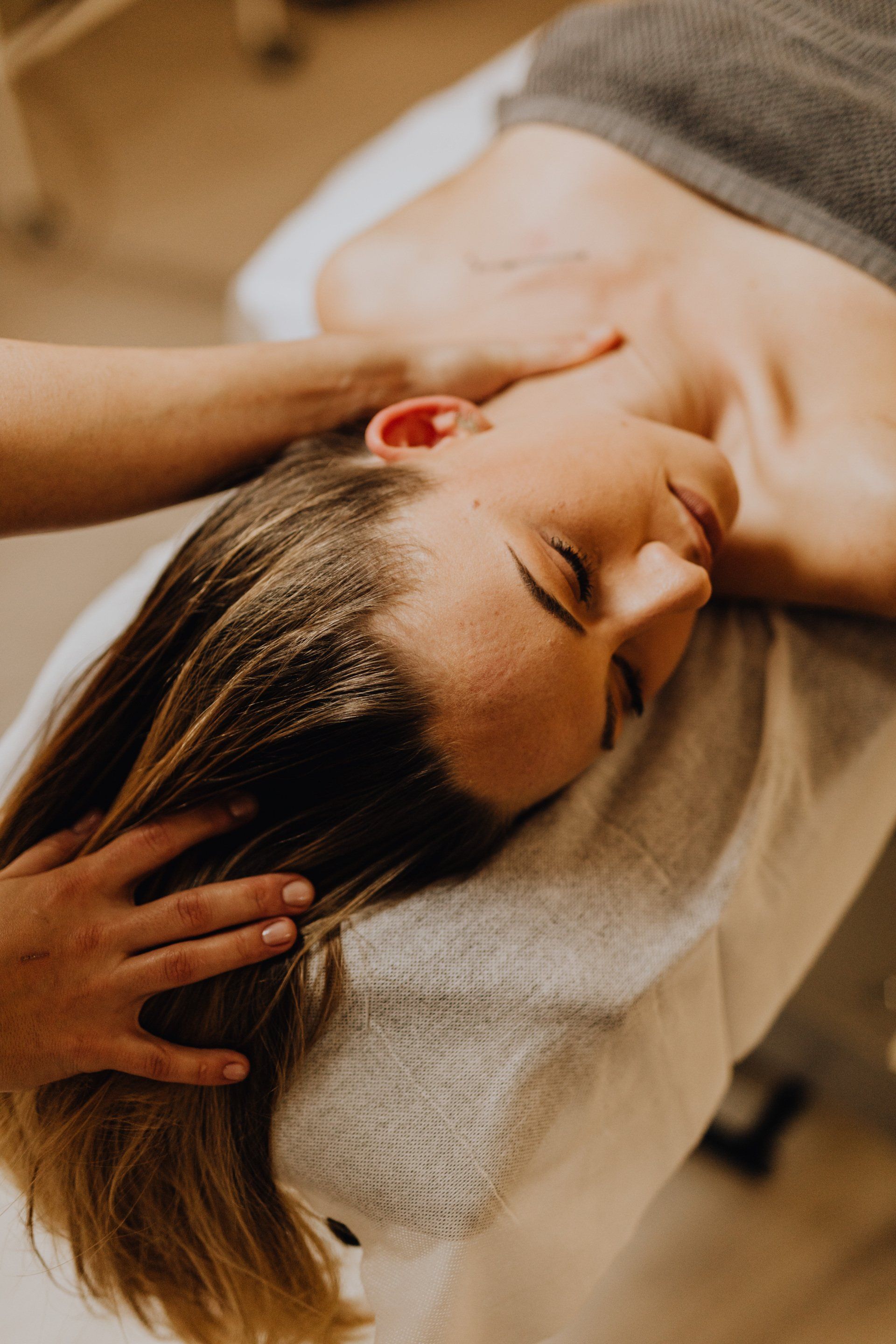 A woman is getting a facial massage at a spa.