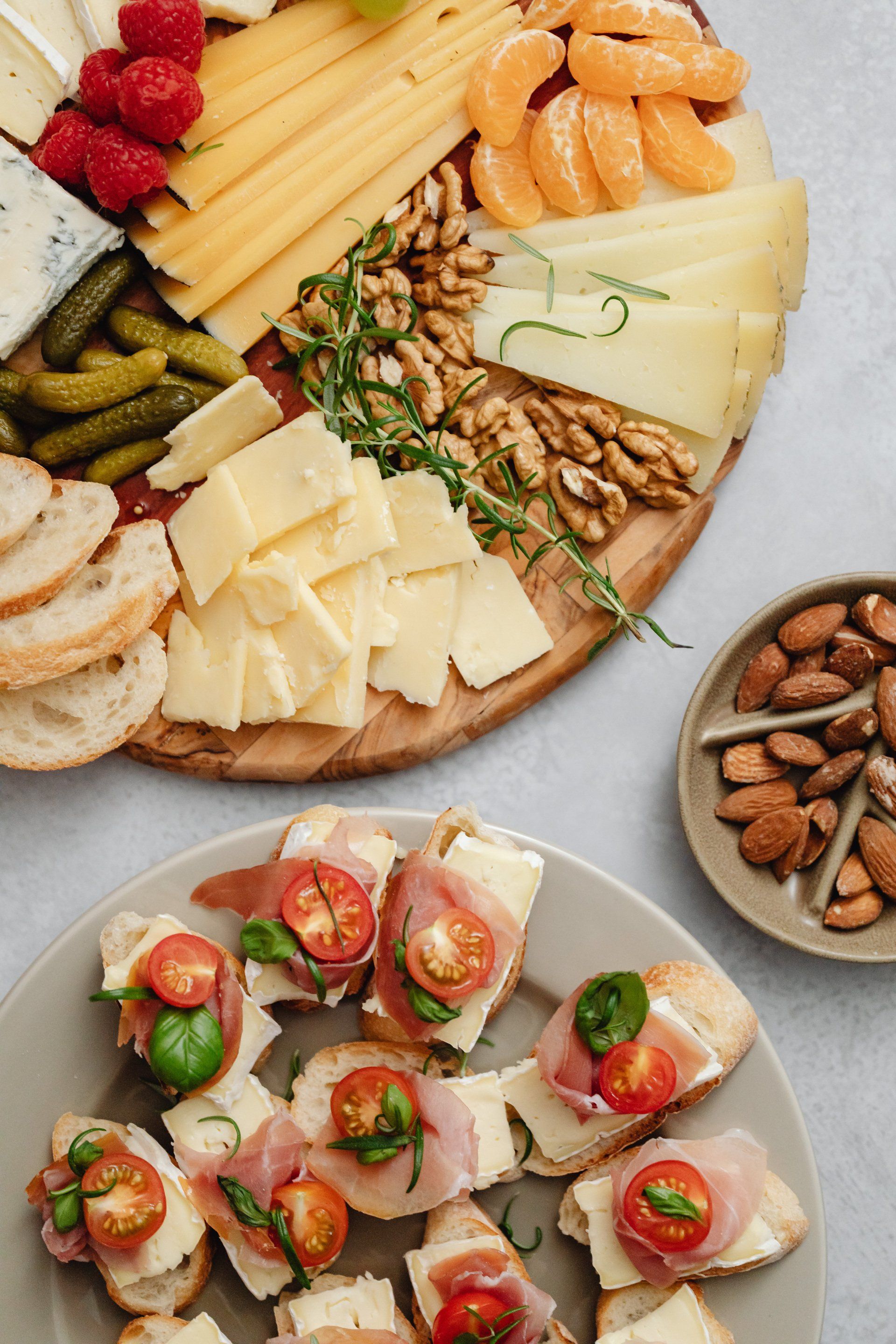 Charcuterie board featuring cheese, nuts, and bread on a wooden platter.