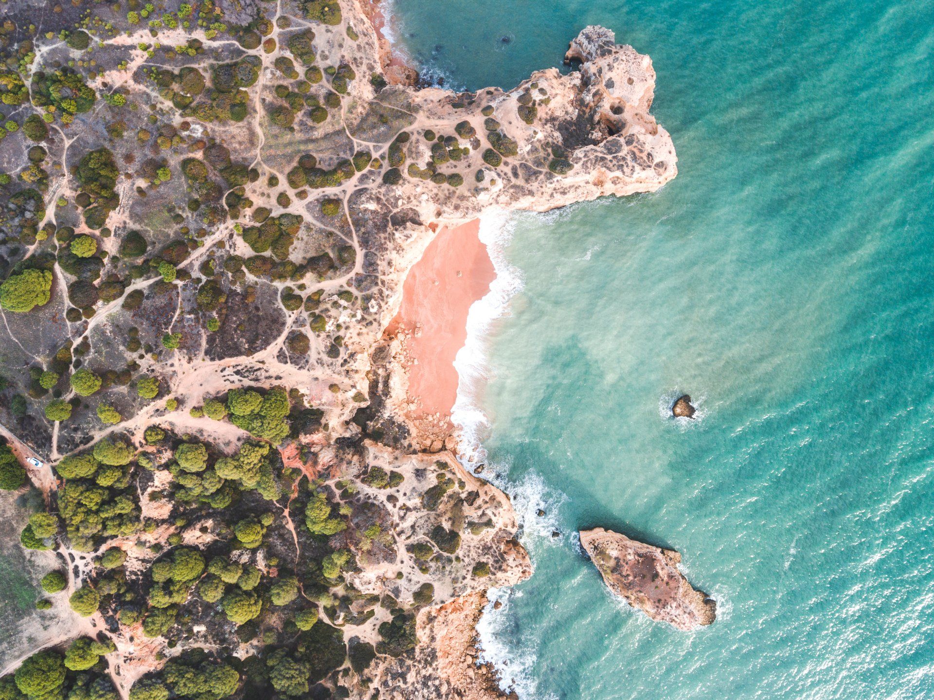 An aerial view of a beach on a cliff overlooking the ocean.
