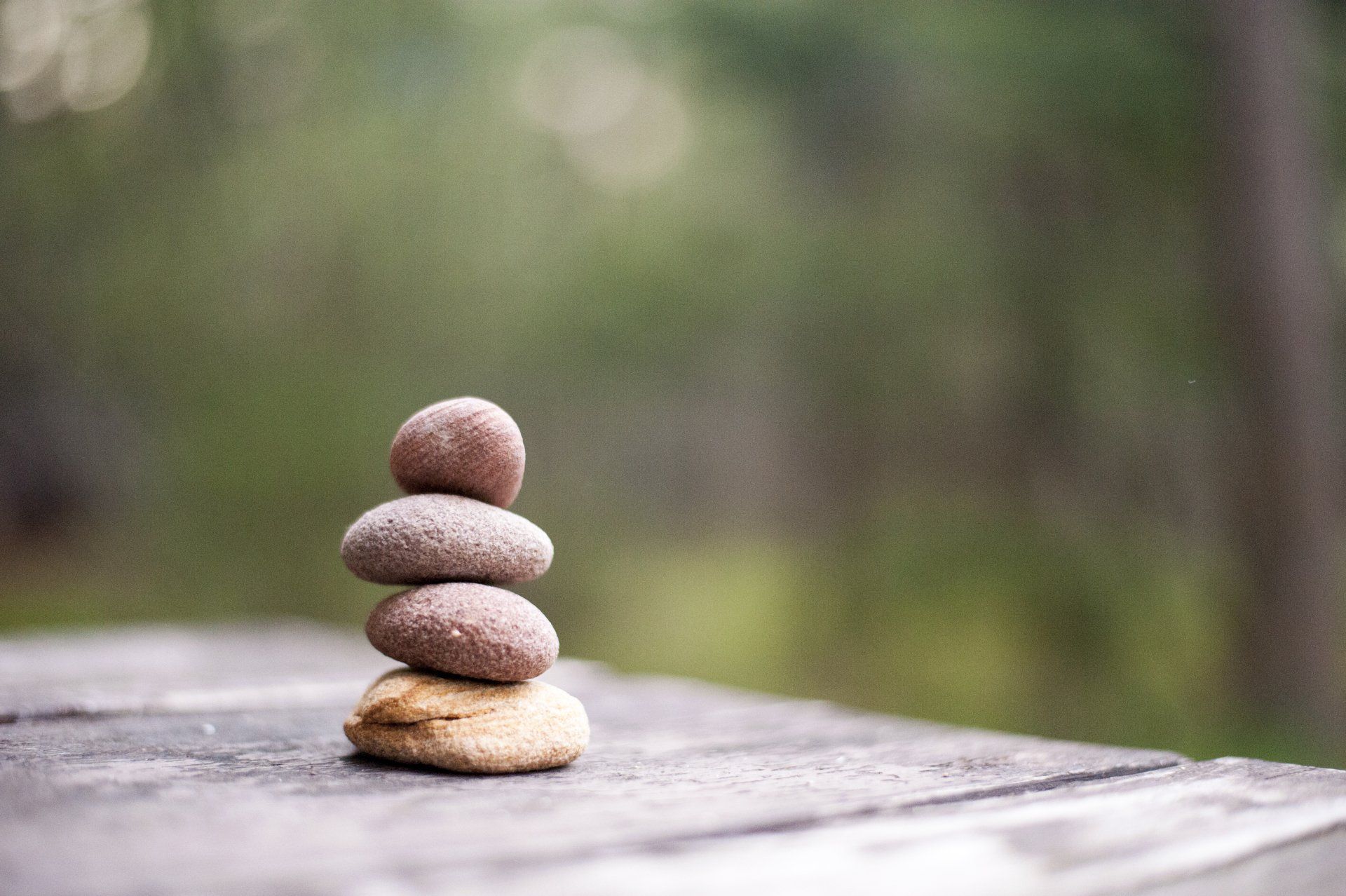 An artistic image of some stones set on top of each other with a blurred background,