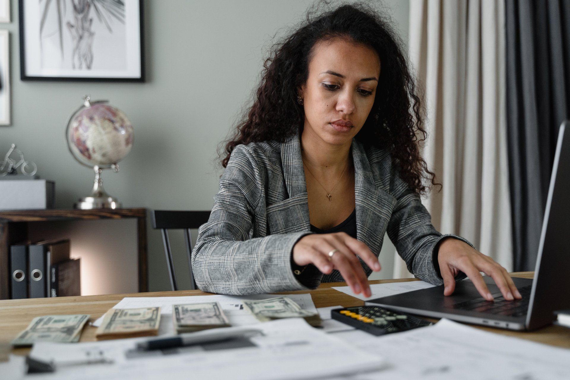 Woman working on computer and counting money.