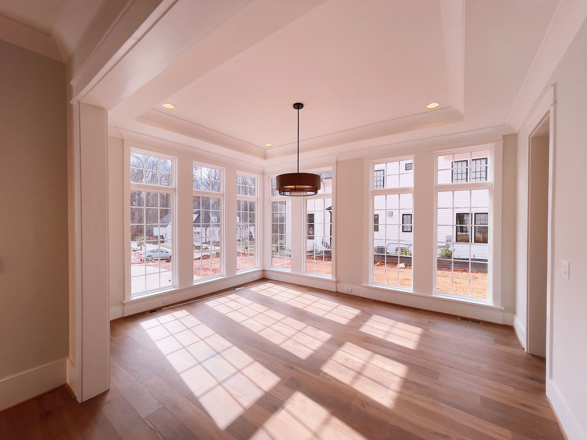 An empty room with a lot of windows and a chandelier