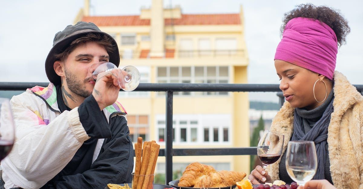 A man and a woman are sitting at a table drinking wine.