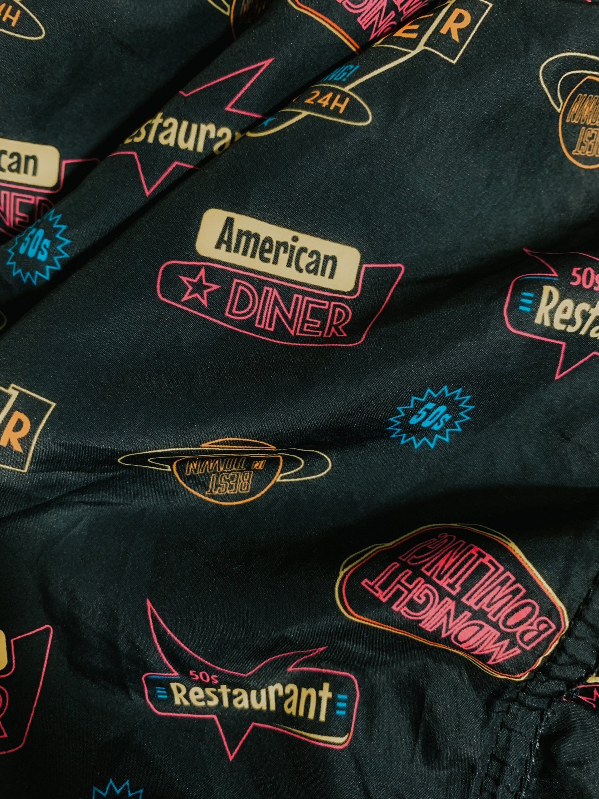 a black cloth with neon signs that say american diner