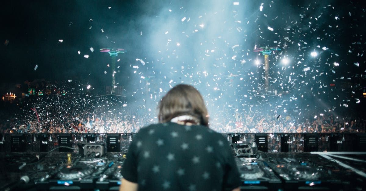 A dj is playing music on a stage in front of a crowd.