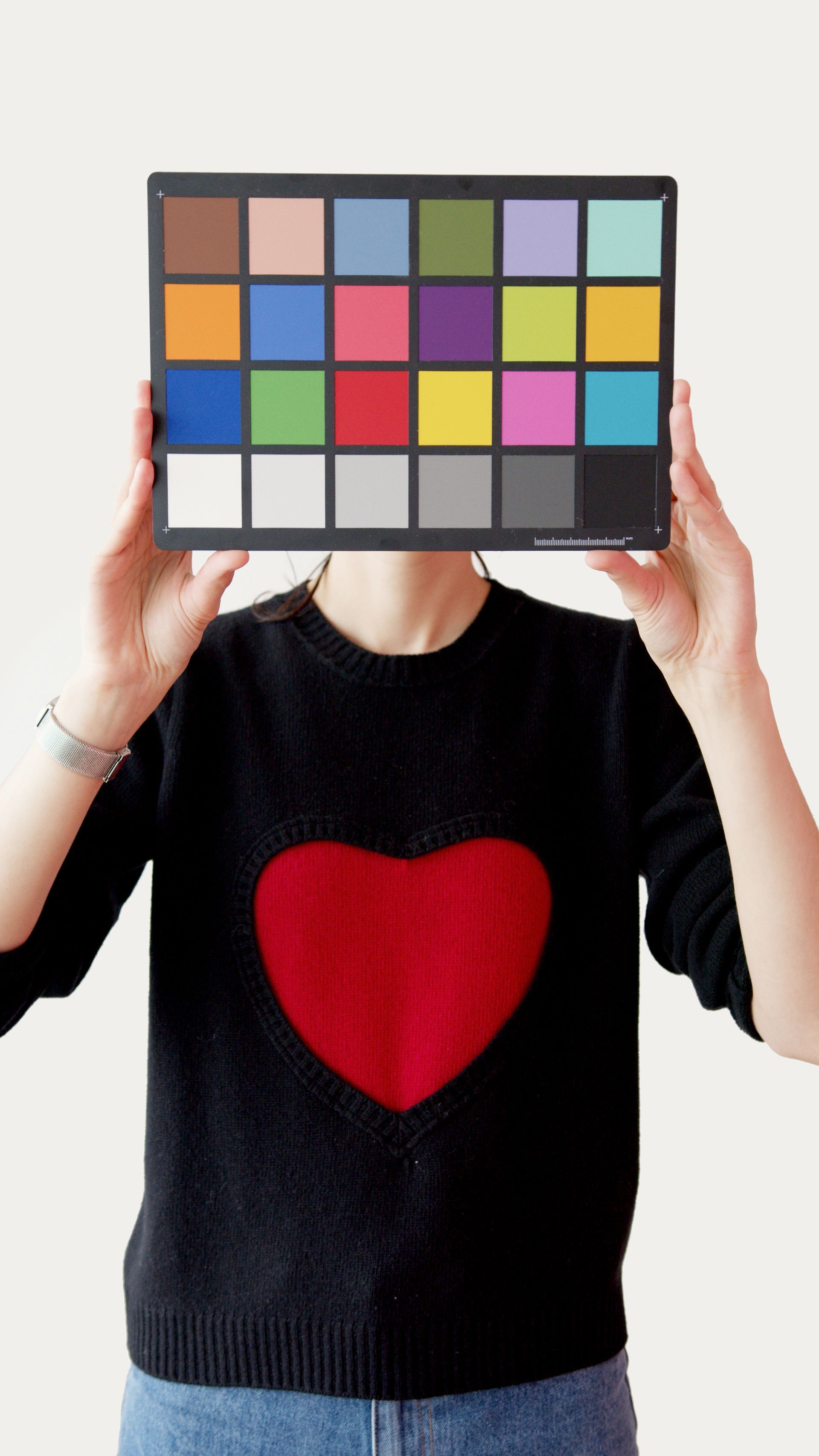 a woman in a black sweater has a red heart on her chest