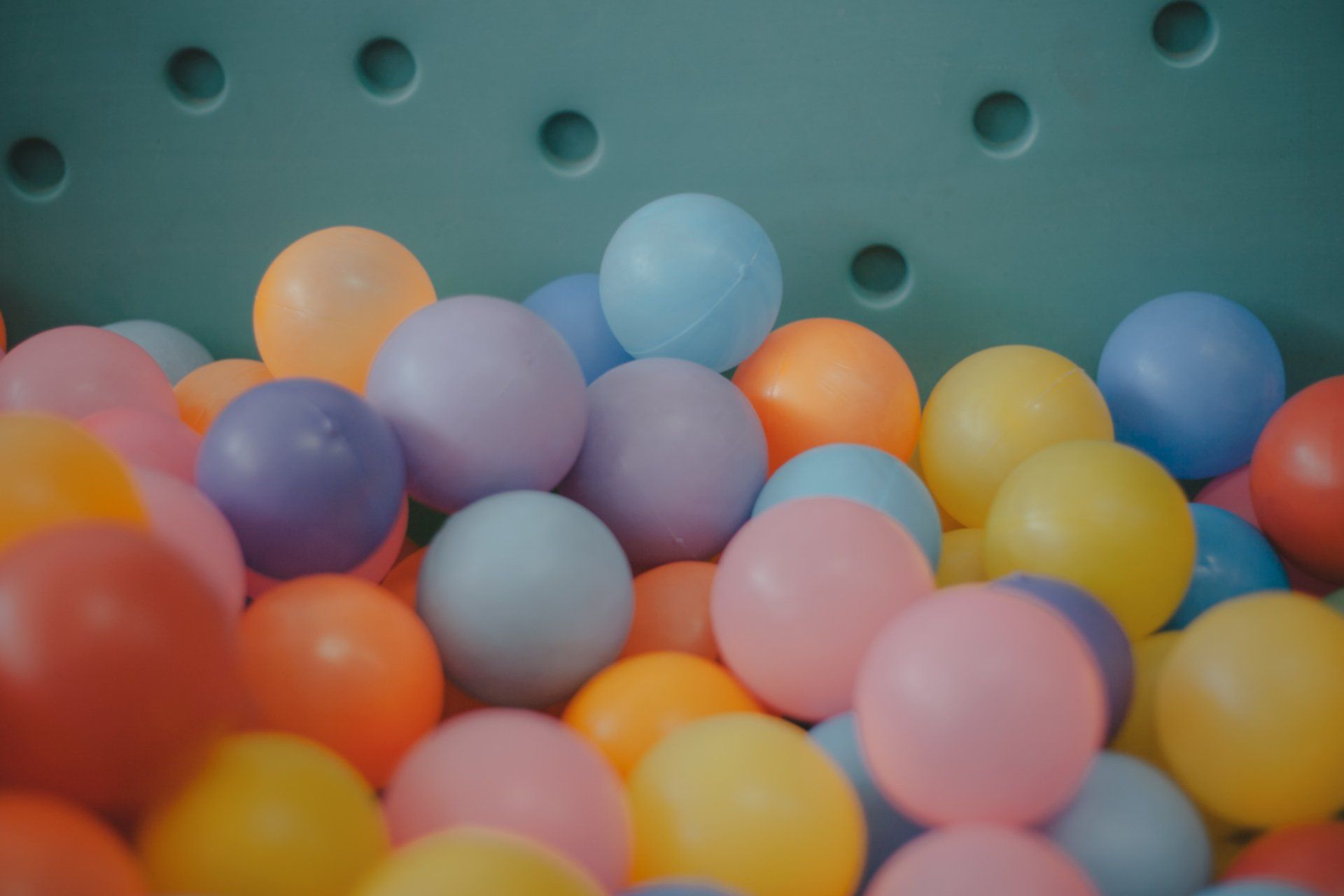 a pile of colorful plastic balls in a ball pit .
