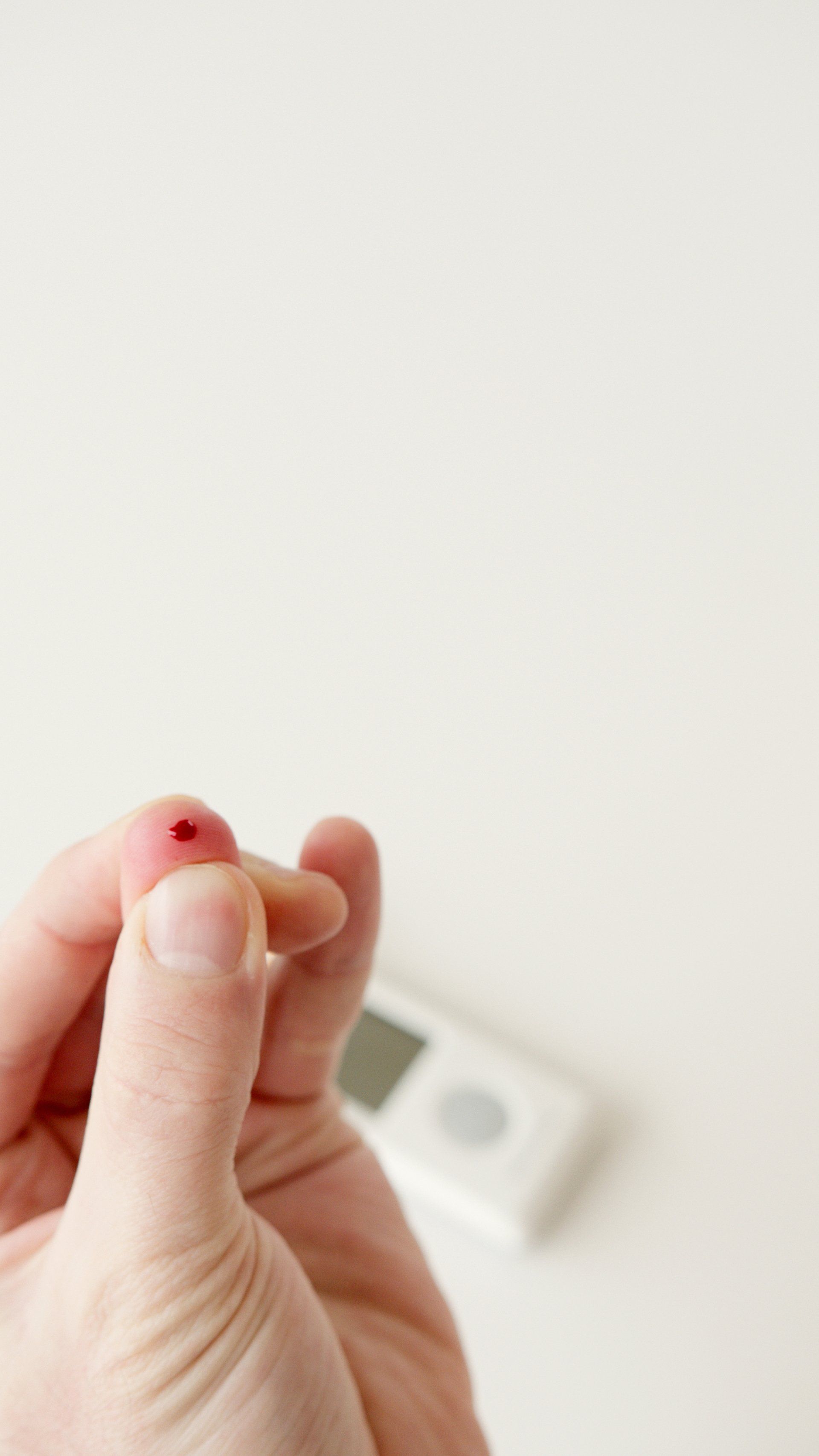 a small spot of blood on the tip of a diabetic person's finger