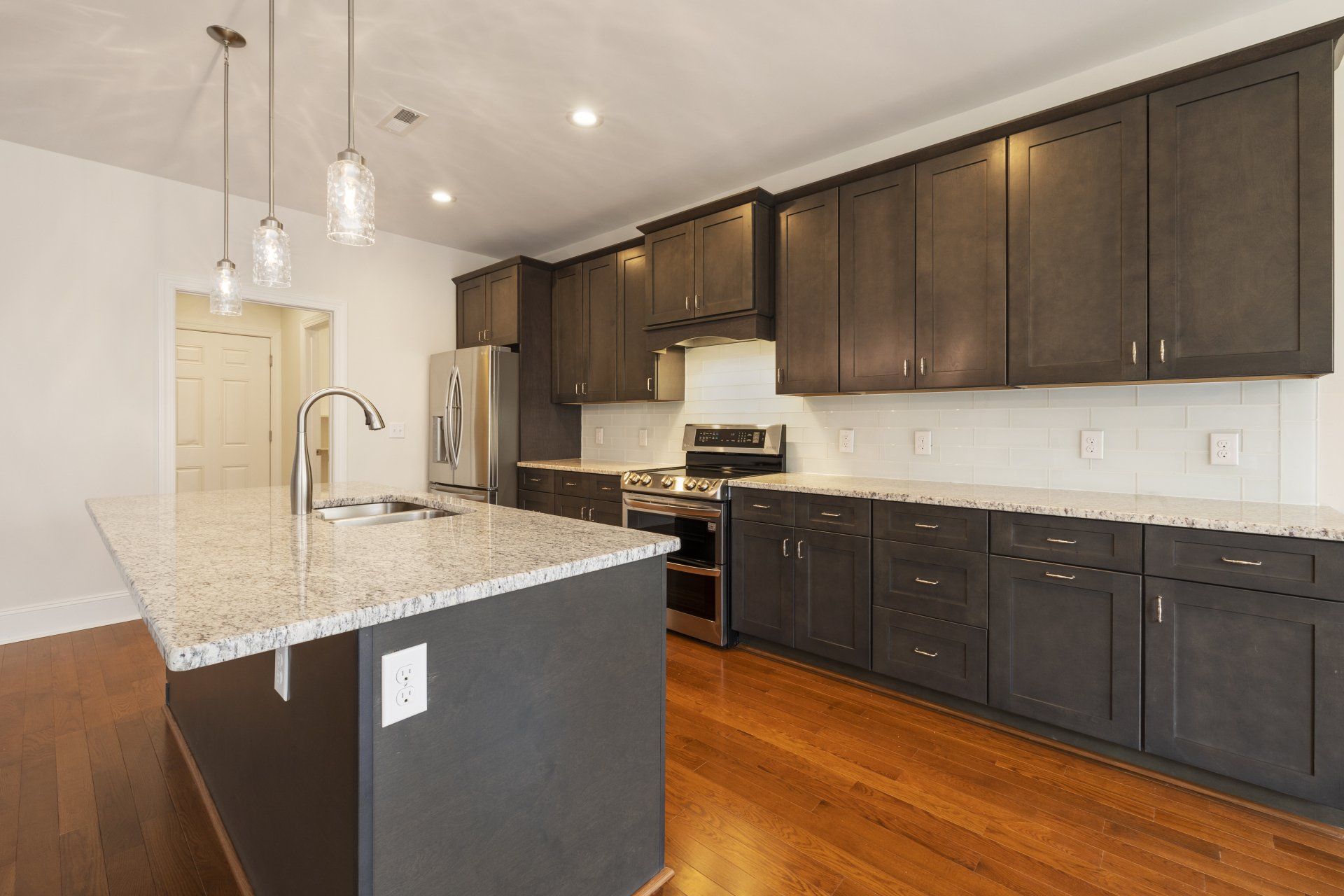 a kitchen with a large island and granite counter tops .
