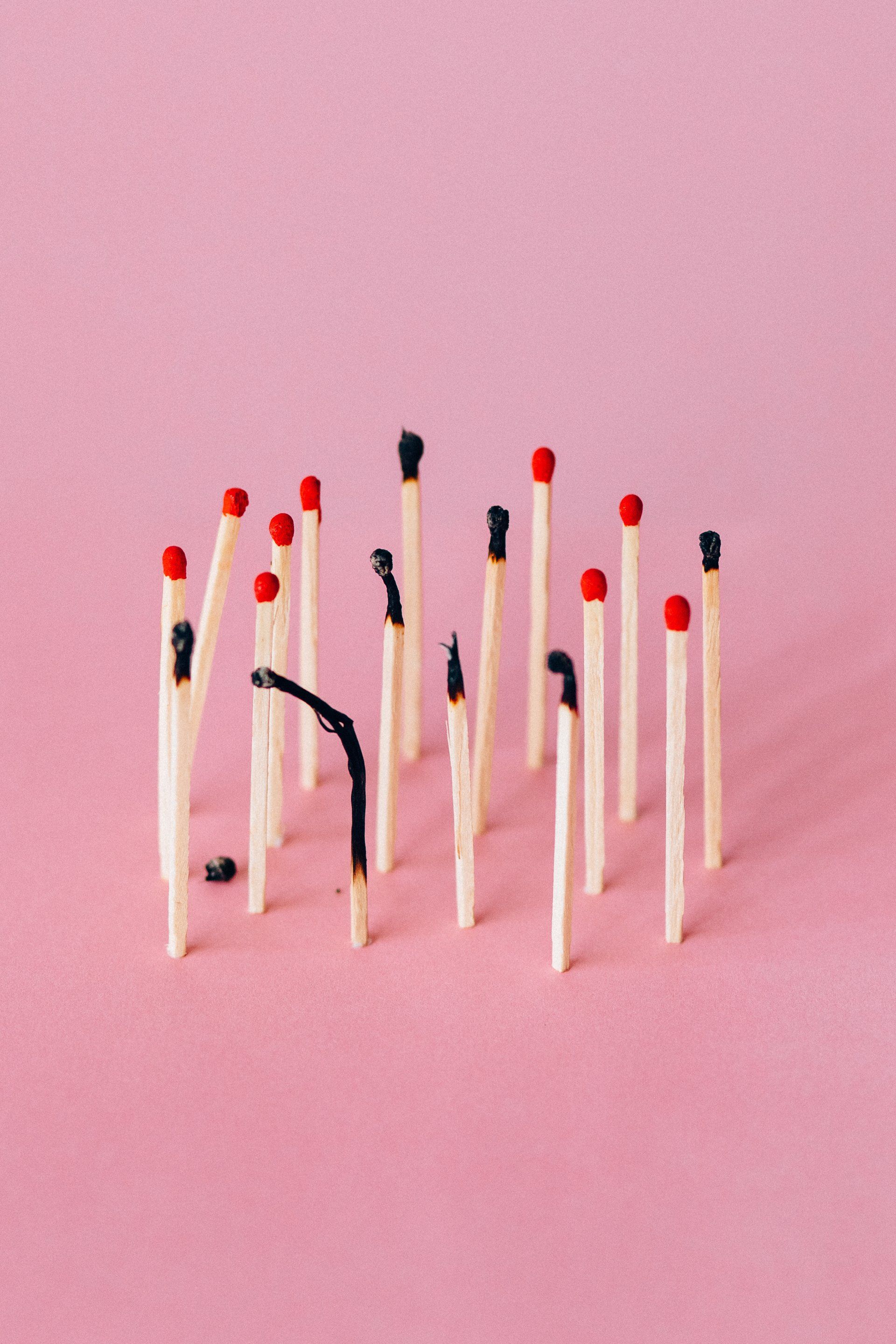 Matches on pink background with a few burned matches