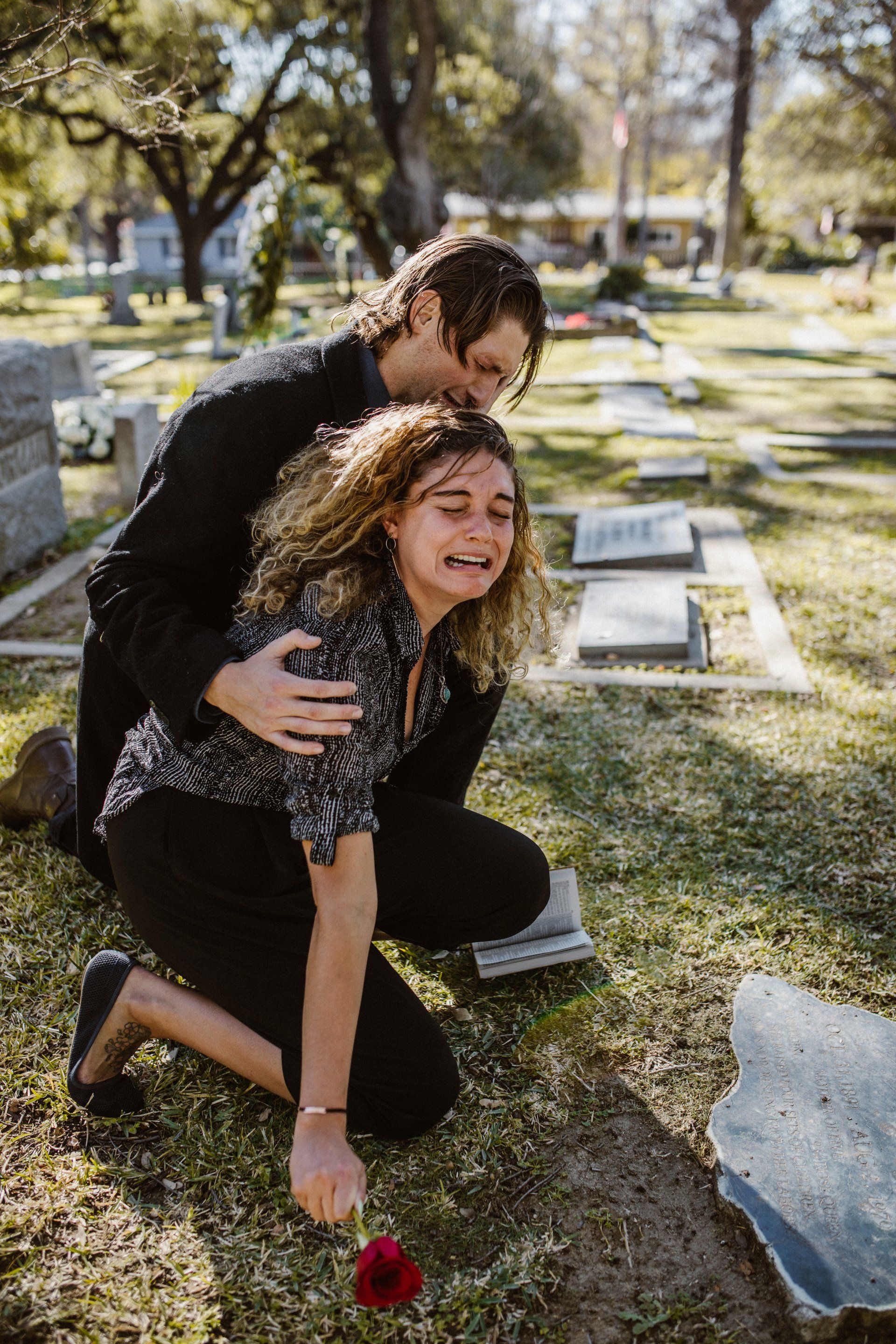 two people emotional at a cemetery