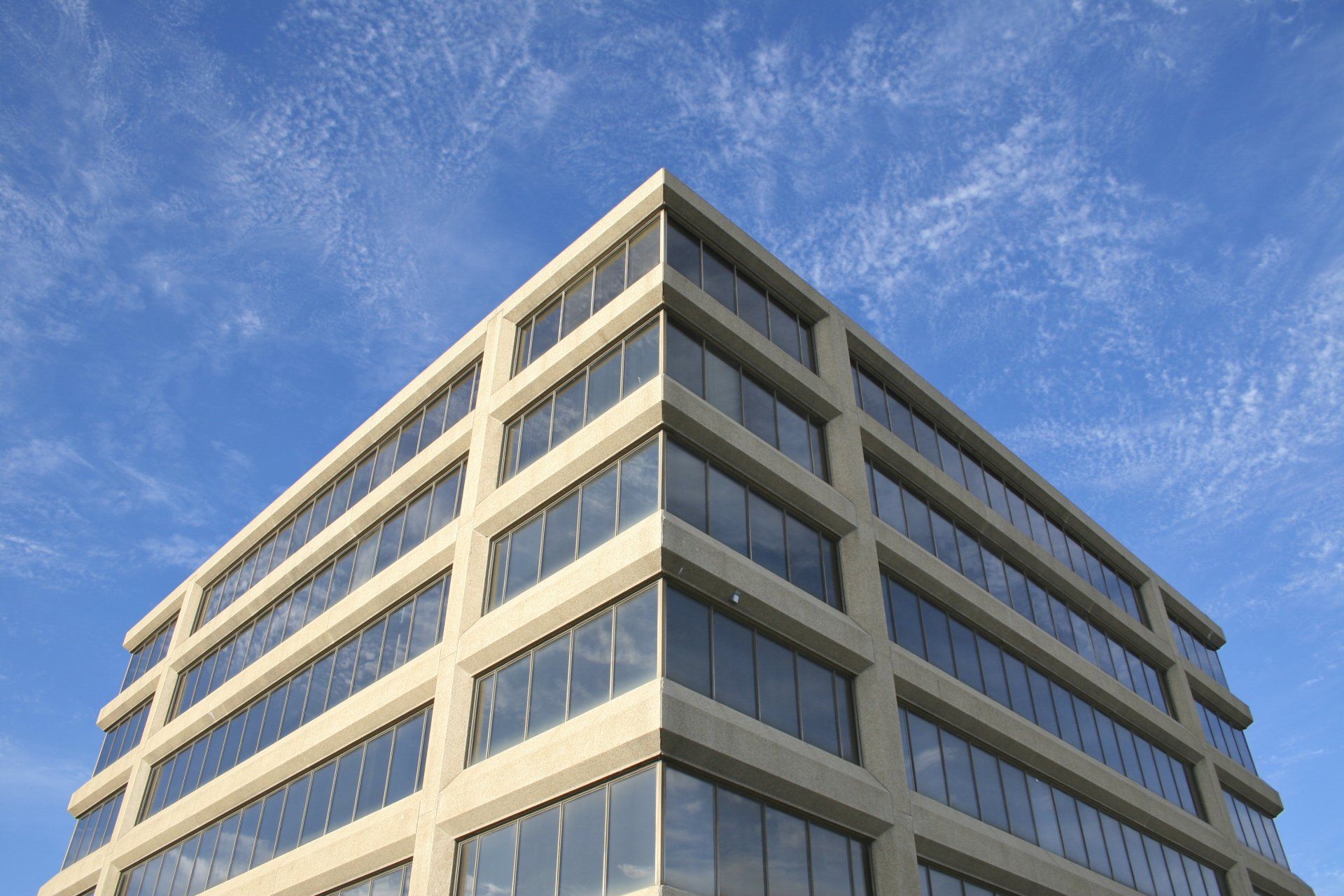A multistory office building with a blue sky background